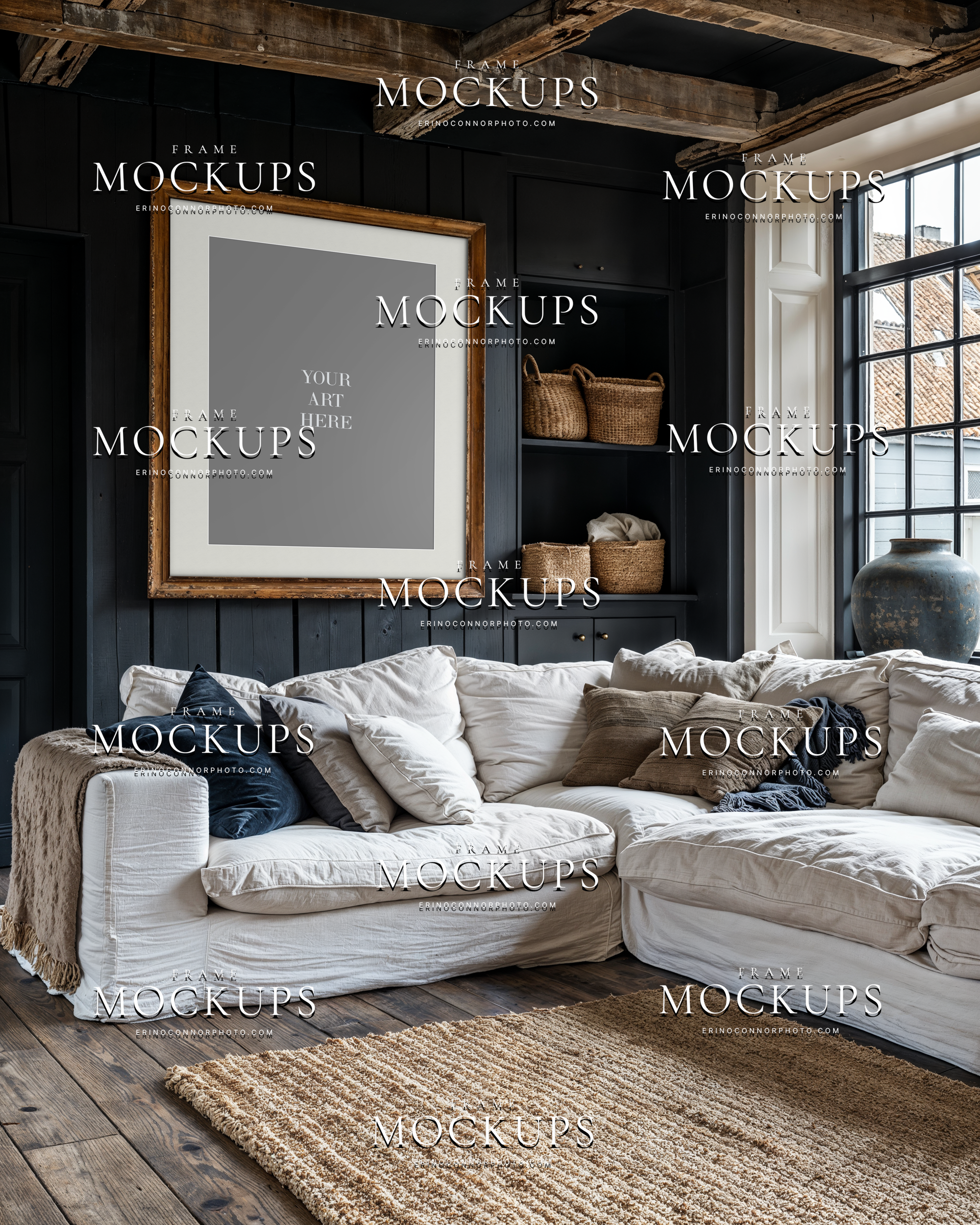 rustic modern interior mockup with empty vertical frame above white sectional sofa, black paneled wall, exposed reclaimed beams, and warm woven storage baskets