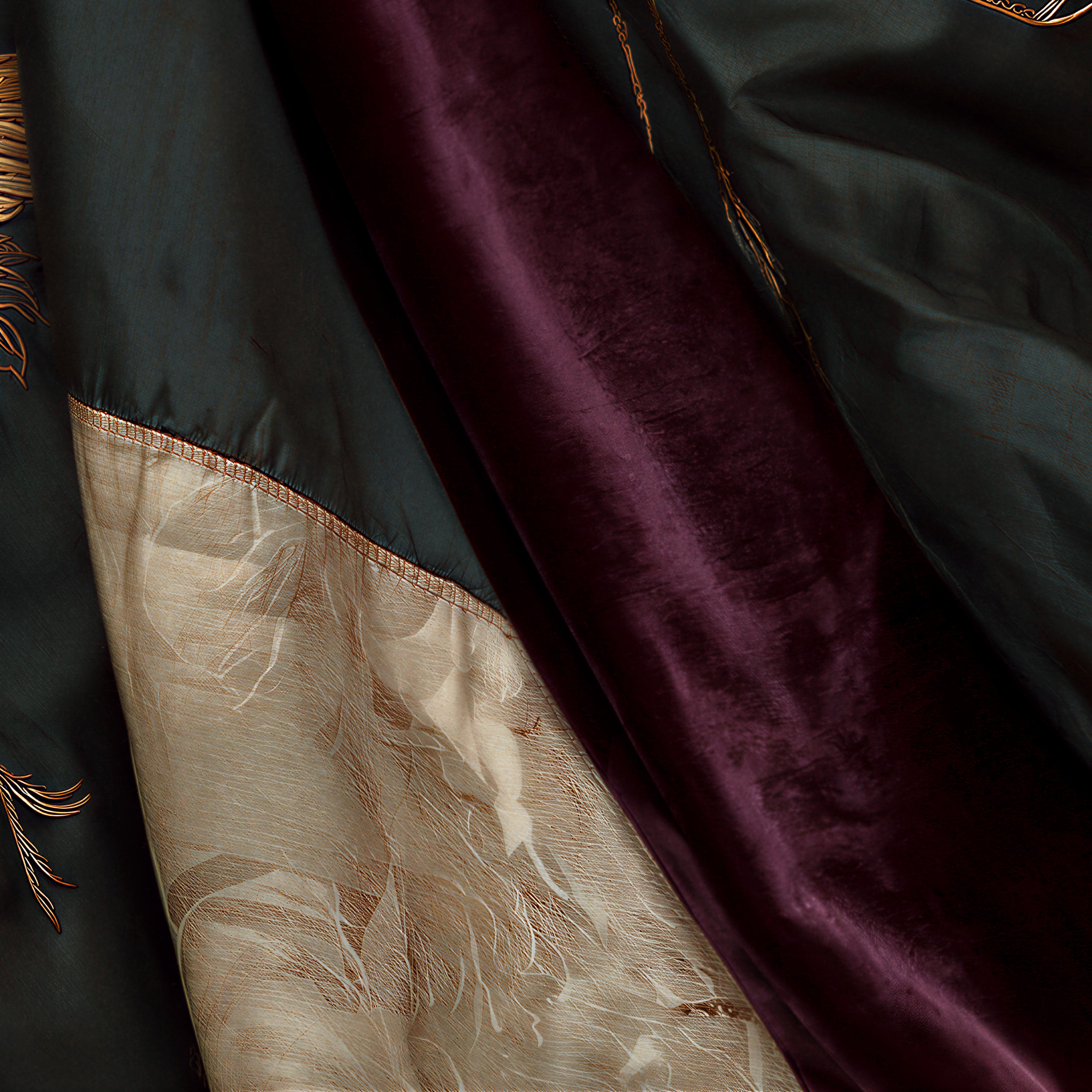 Close detail of the muted burgundy inner edge beneath the deep green embroidered textile worn by Zuri.