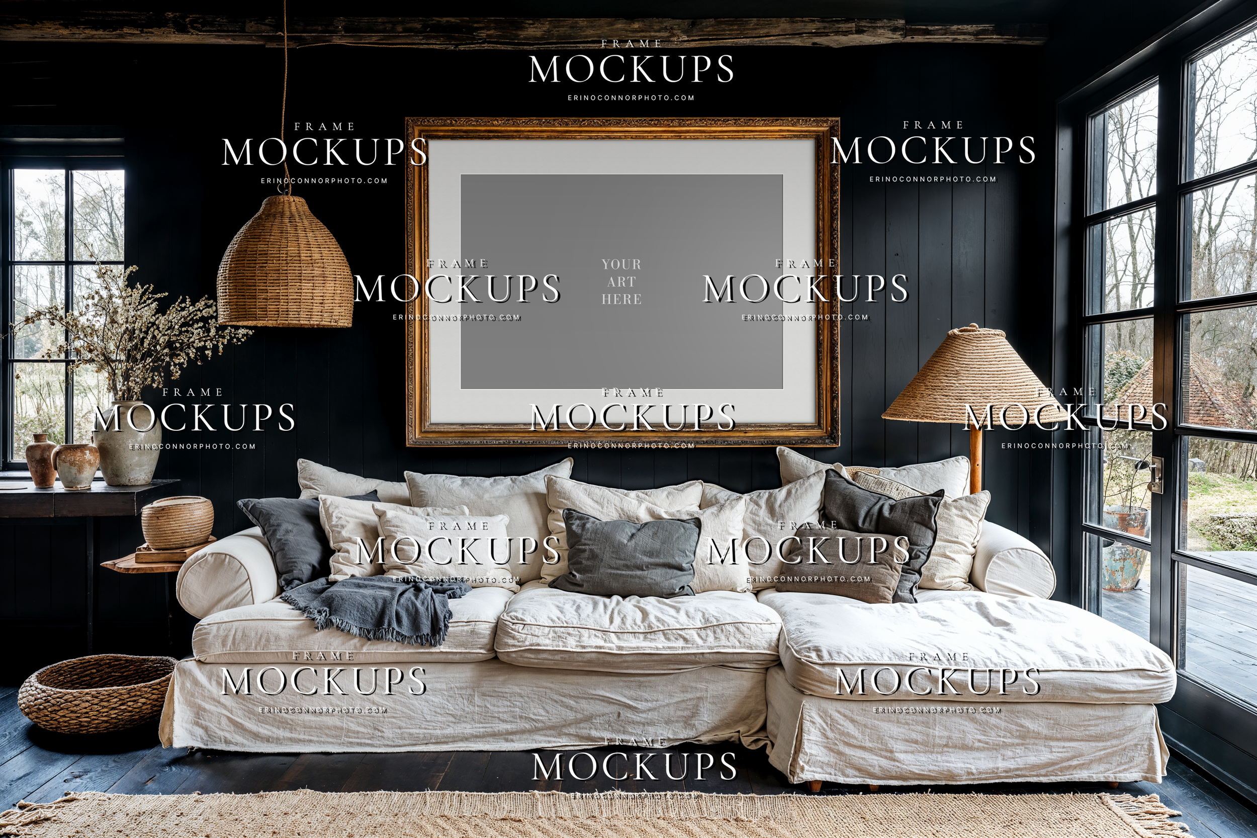 rustic modern living room mockup with empty horizontal frame above white slipcovered sofa, dark paneled wall, wicker lighting, and warm natural textures