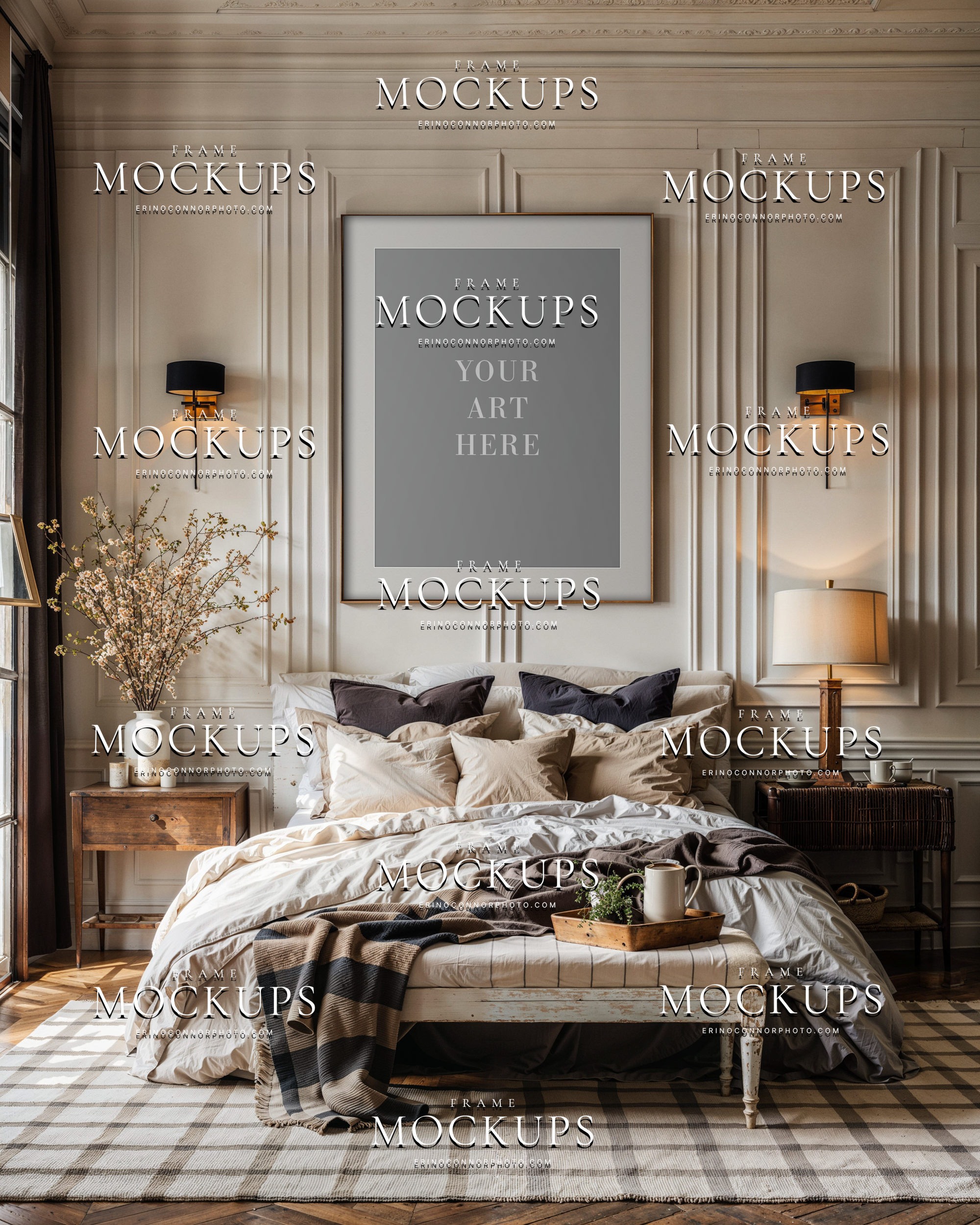 Empty vertical wall art mockup in a modern farmhouse bedroom with paneled walls, layered neutral bedding, black sconces, wood nightstands, and soft natural light