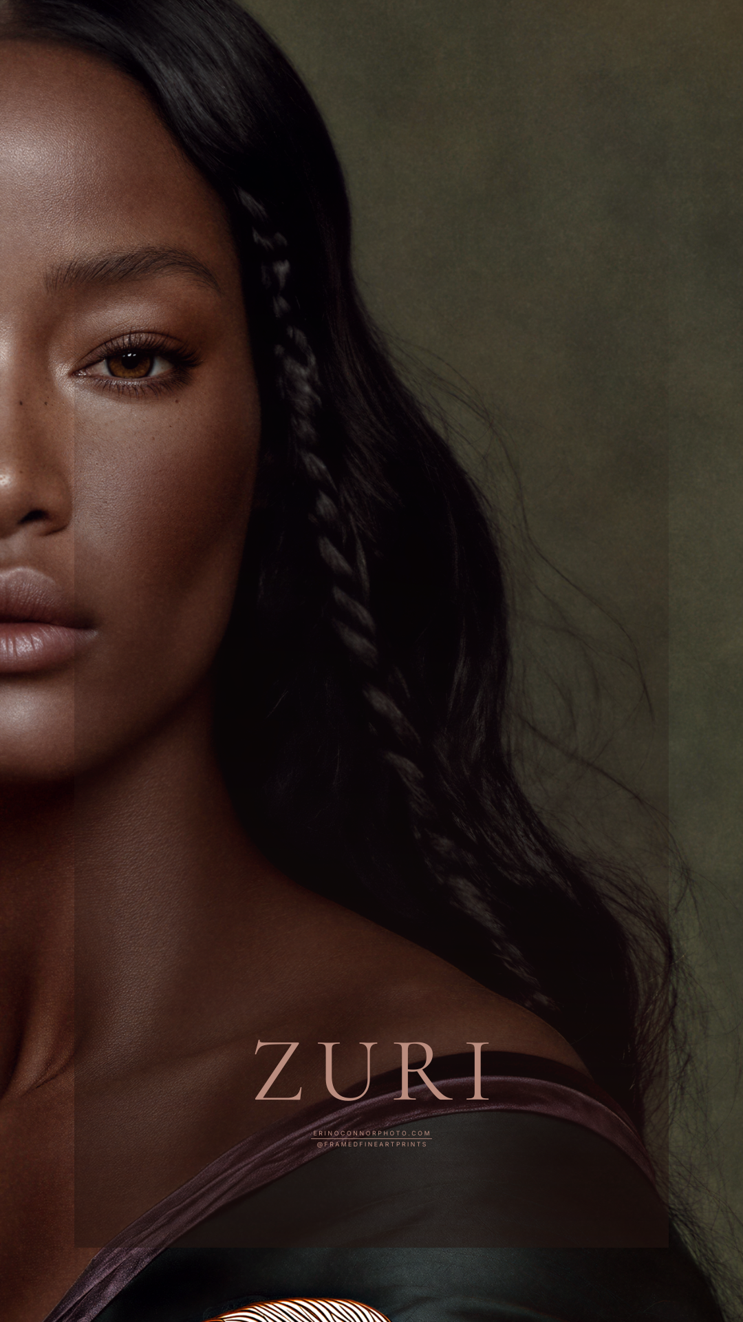 Close portrait of Zuri with long black hair, a direct gaze and one shoulder exposed above a deep green embroidered garment.