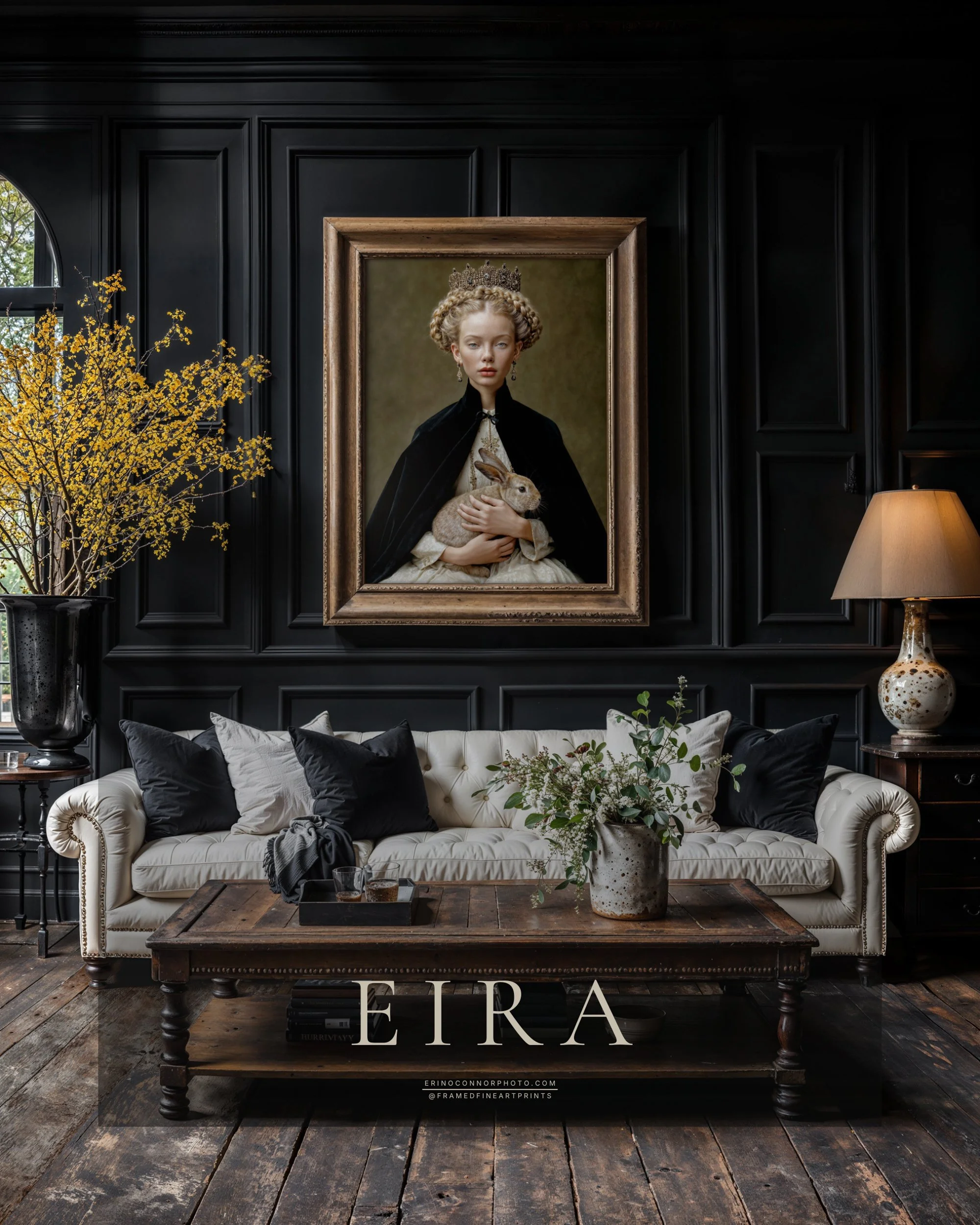Large framed Eira fine art portrait displayed above a white sofa against black paneled walls in an elegant living room.