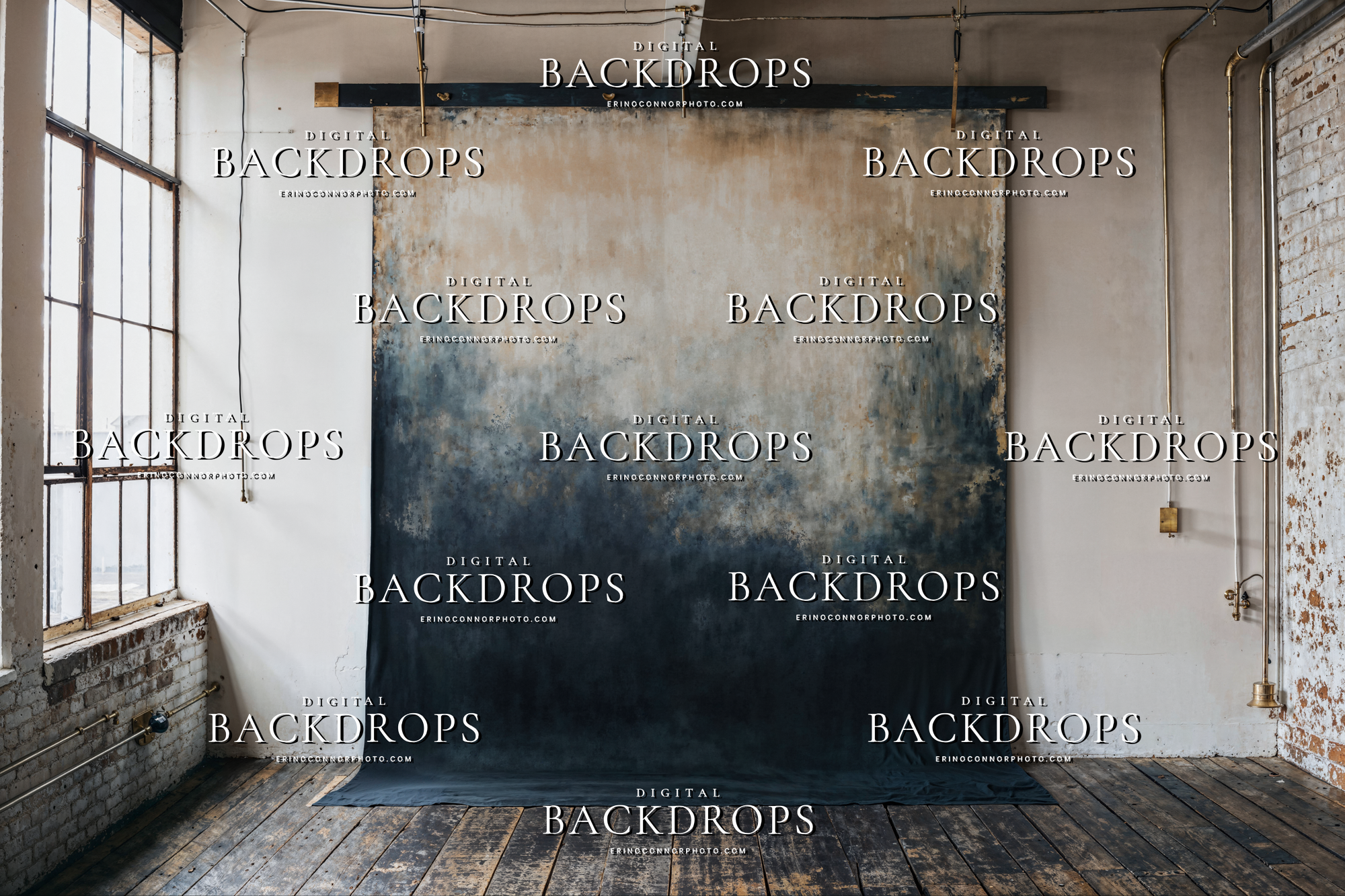 Large horizontal painterly canvas backdrop in a loft studio, beige top and deep navy base, brass pipe hang, distressed walls, moody portrait background.
