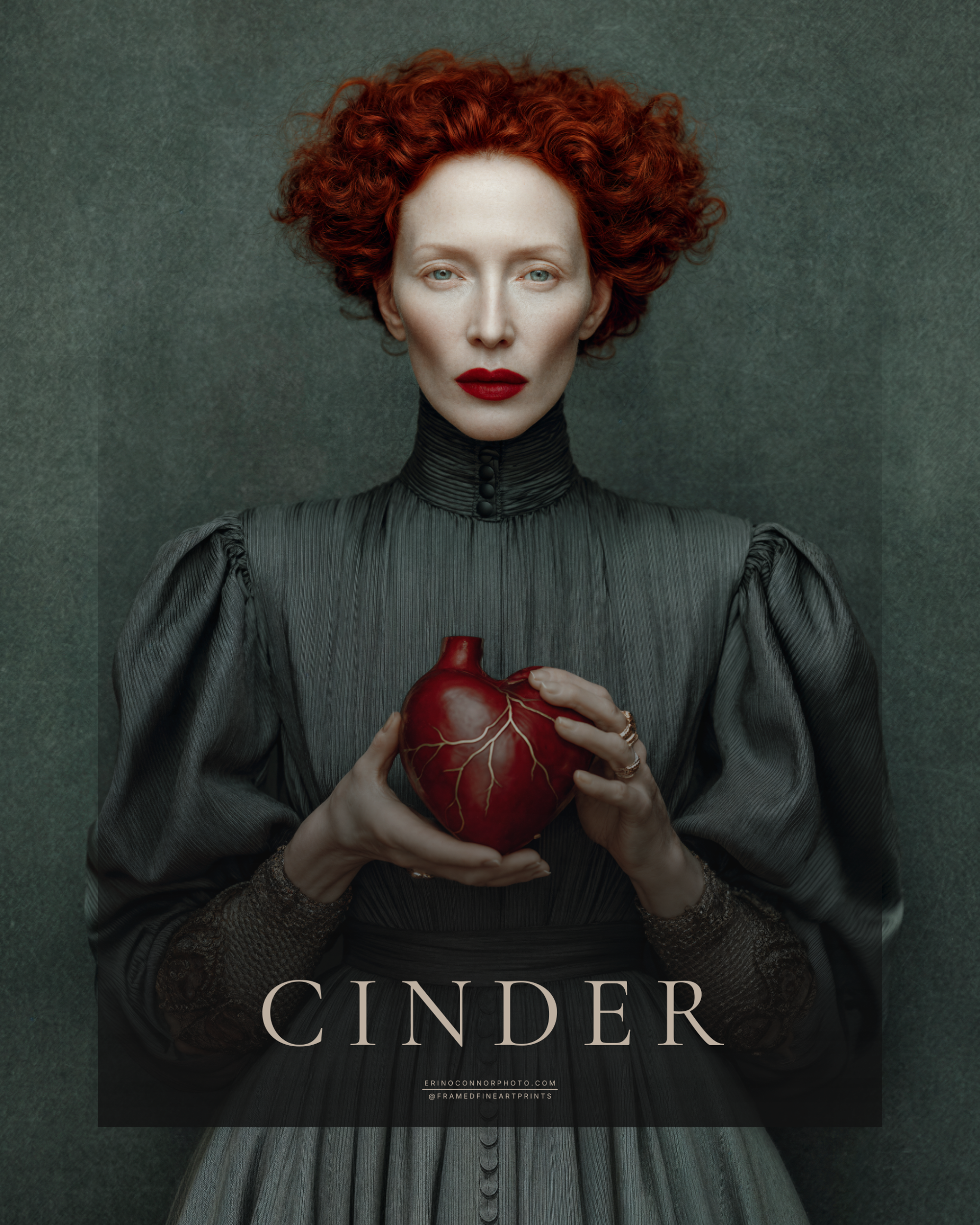 Cinder fine art portrait of a red-haired woman in a charcoal gray dress holding a red anatomical heart marked with gold repair lines.