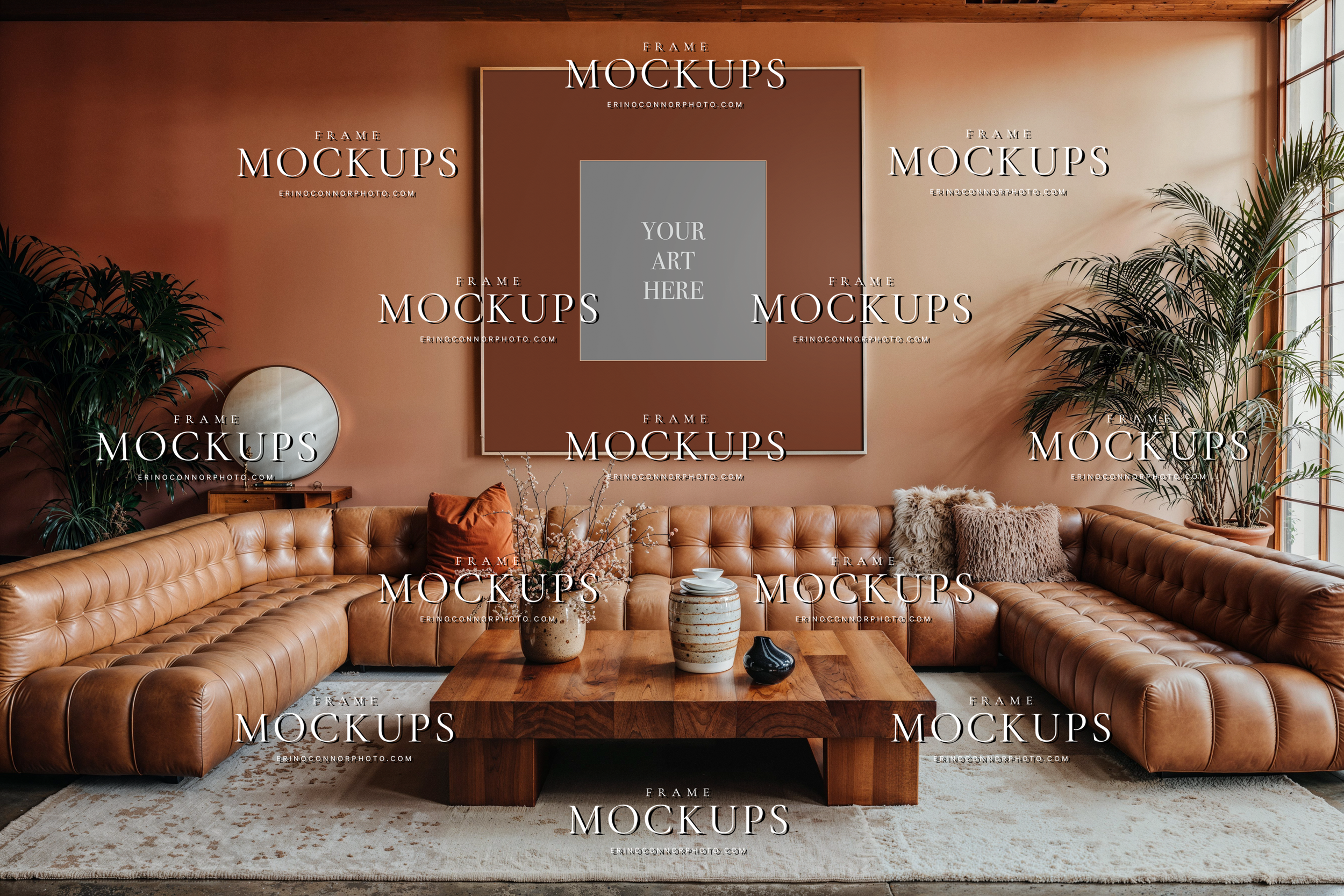 Empty square wall art mockup in a California Casual living room with clay wall, cognac tufted sectional, sculptural wood table, and warm natural light