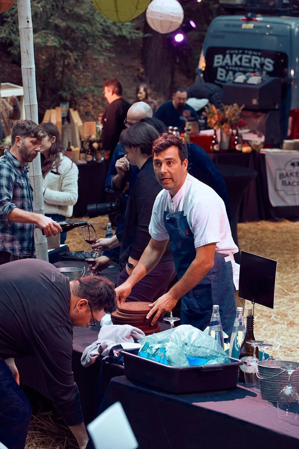 Guests enjoying small bites and wine at a Colectivo Felix festival closing party among the redwoods