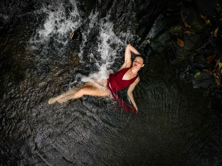 Client lying on her back with arched posture in flattering boudoir lighting