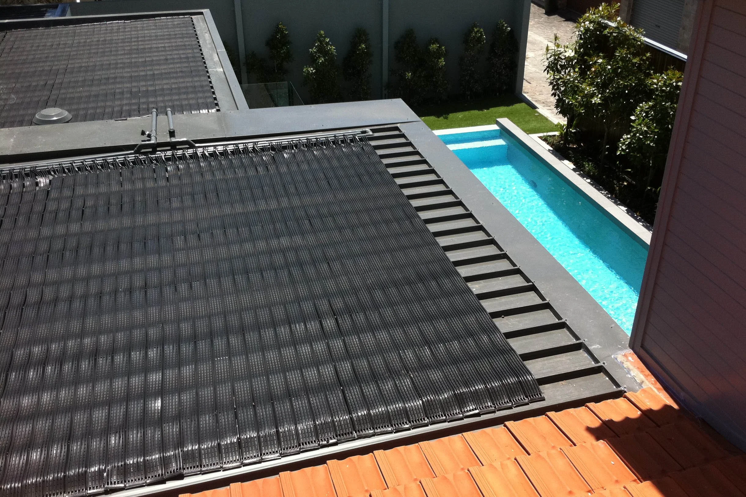 Swimming pool with solar heating system installed on roof