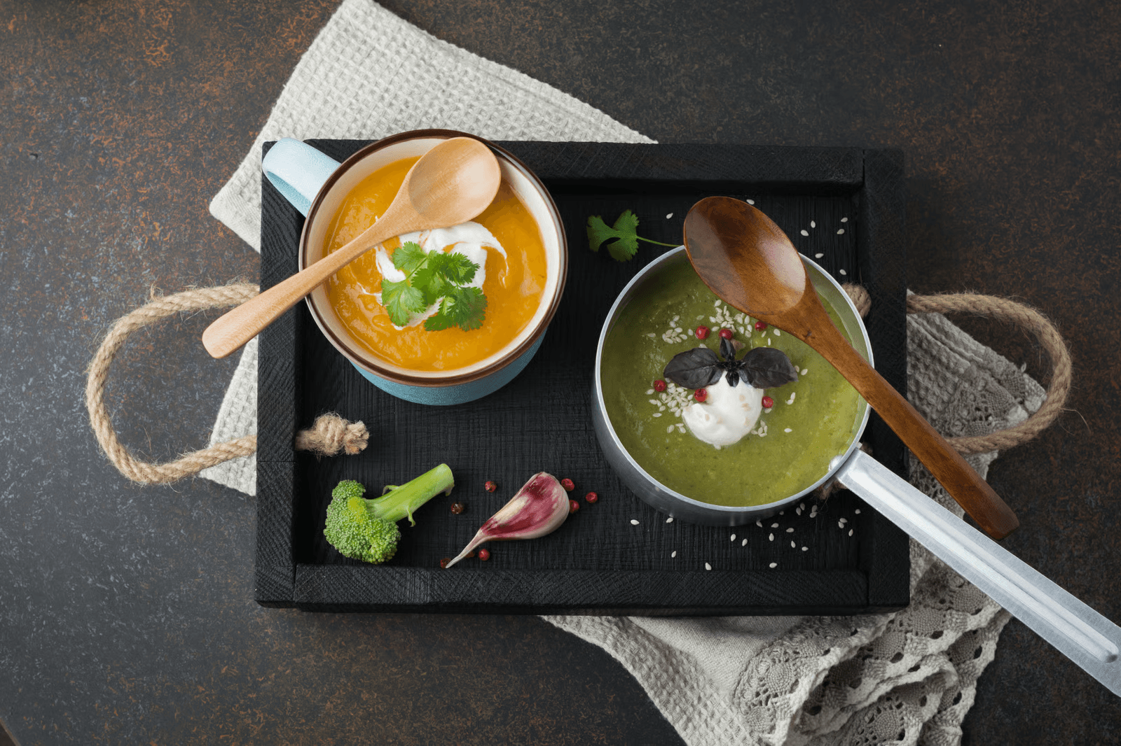 Two bowls of blended vegetable soup served with spoons