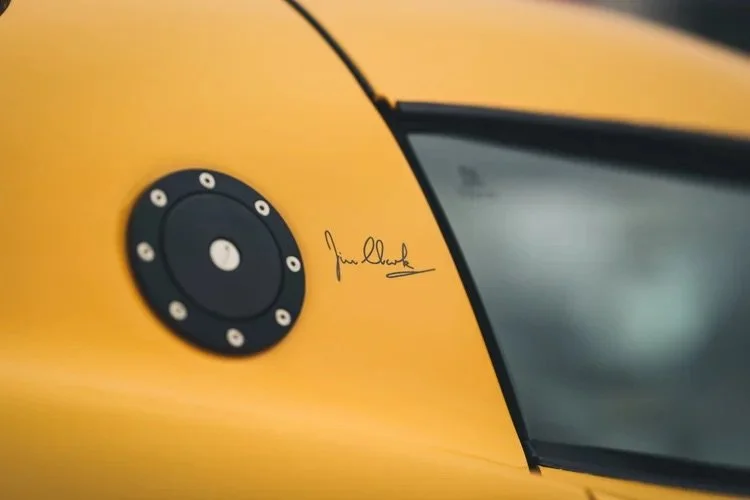 Nahaufnahme eines gelben Autos mit einem schwarzen Gasdeckel und einer Unterschrift.