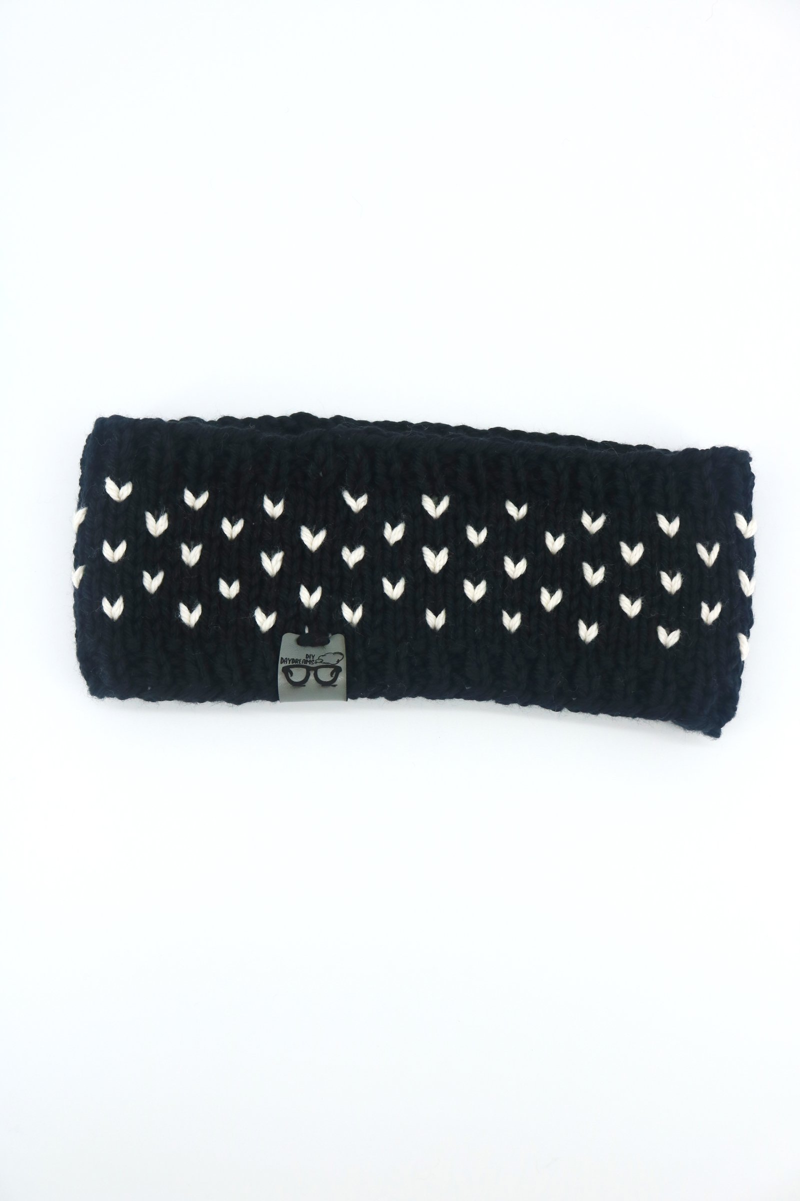 a black cotton headband with tiny white hearts lays on a white background
