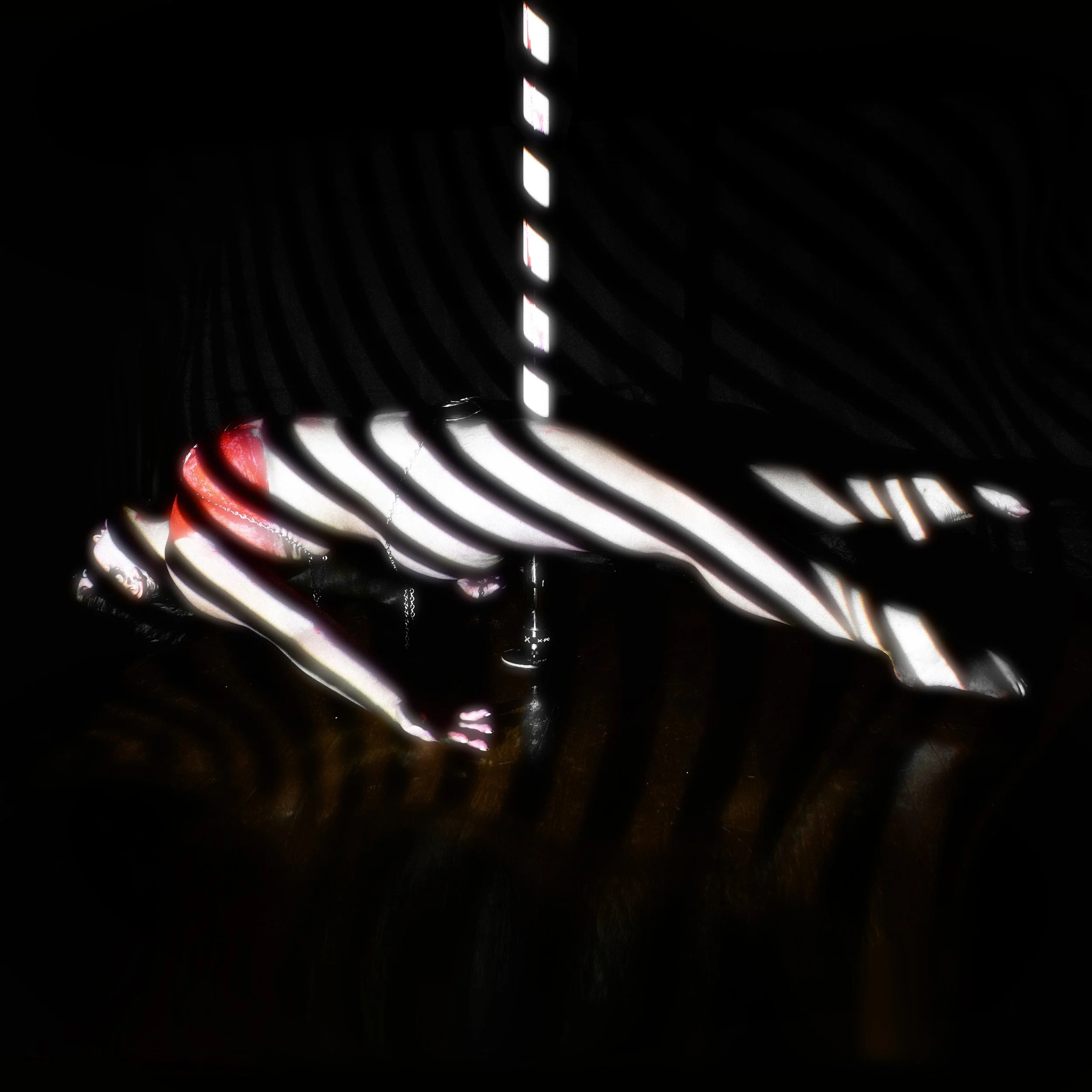 Dark scene with striped black and white artwork and a red object in the background.