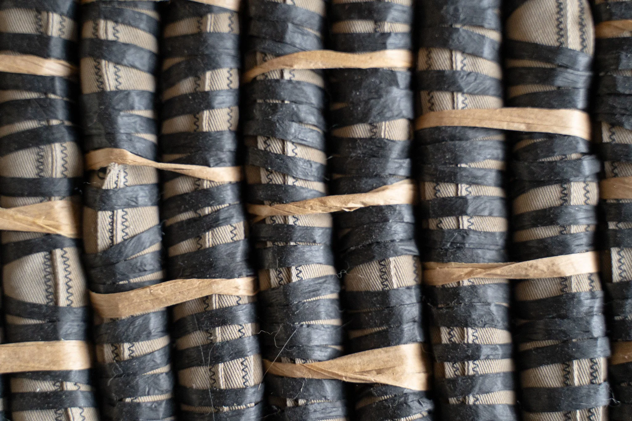 Amanda Martínez, Arrodillarse, 2023 (detail). Found textile webbing filled with sand, woven and dyed raffia fibers. 40.5 x 18 x 1. Courtesy of the artist and HESSE FLATOW, New York.
