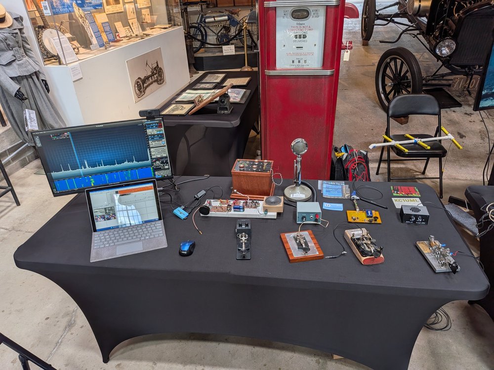 W1BB museum display with radio equipment, Morse keys, laptop, and historical artifacts