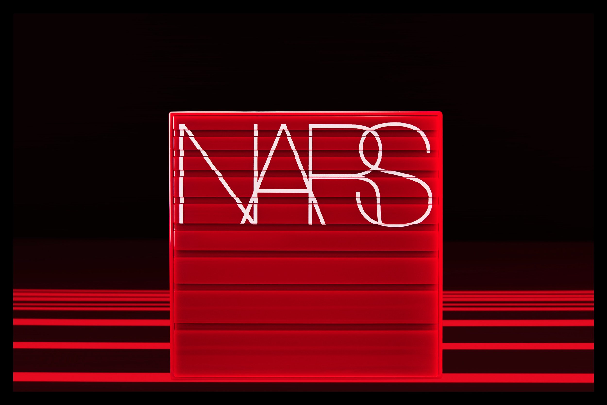 A neon sign with the NASA logo illuminated in white on a red rectangular background, set against a dark background with horizontal red lines.