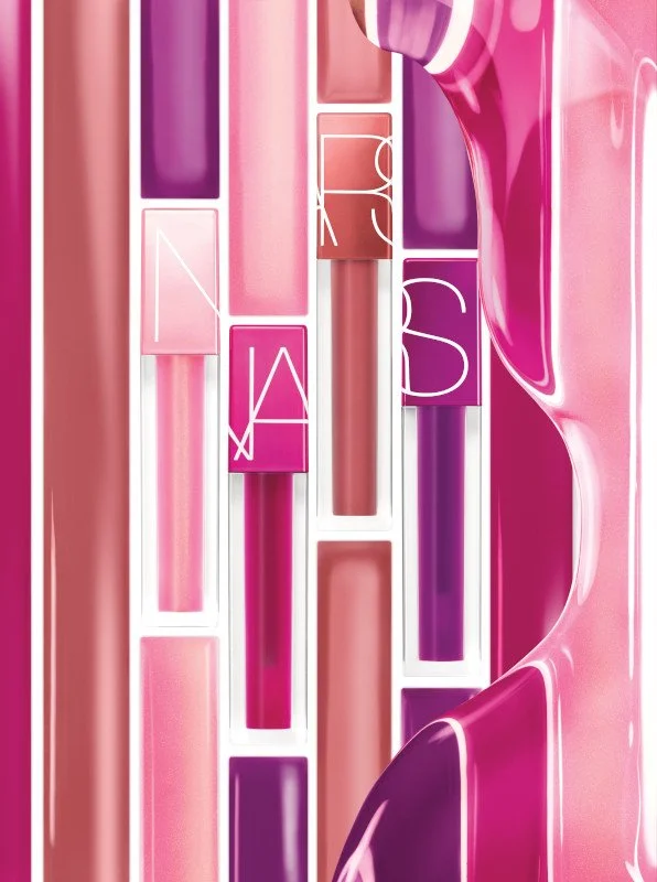 Collection of lip gloss tubes in shades of pink and purple.