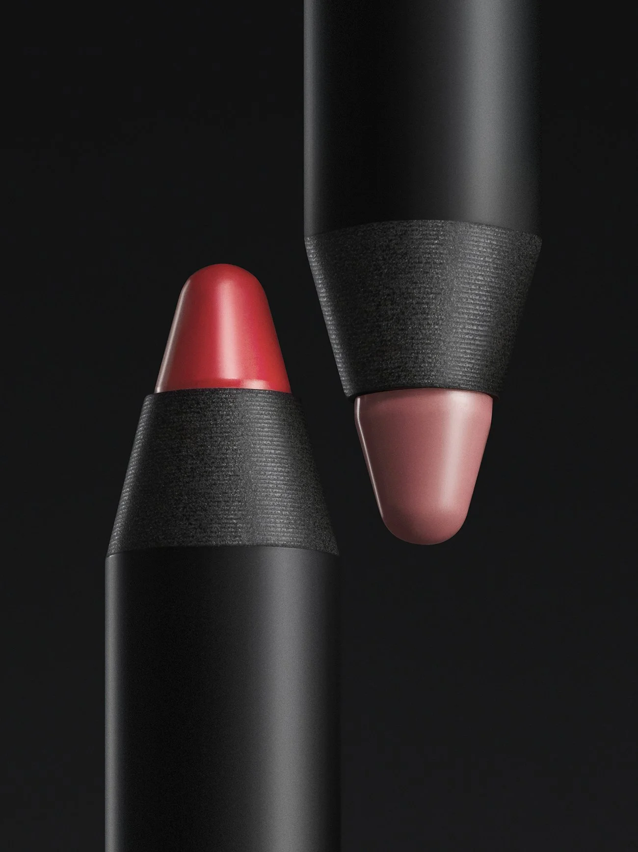 Close-up of two modern lipstick tubes with black bodies, one with red lipstick and the other with pink lipstick, against a black background.