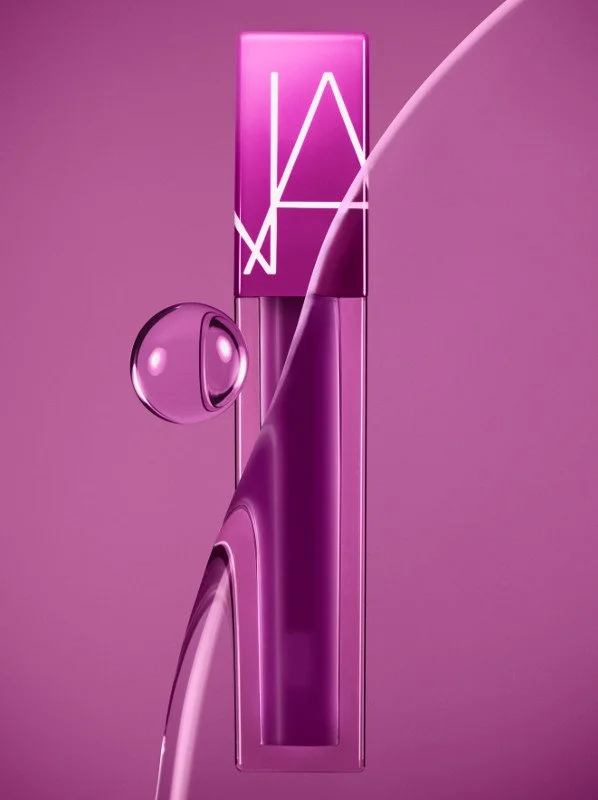 A digitally rendered image of a pink lipstick with the NARS logo on the cap, set against a pink background with a curved light reflection.