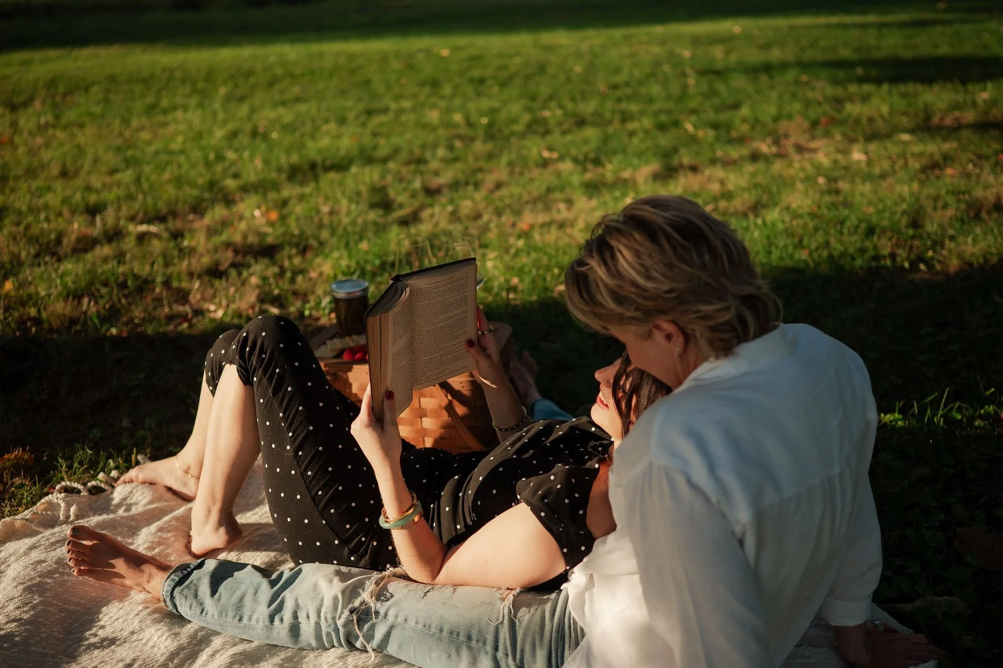 Couple laying together and reading book after a picnic