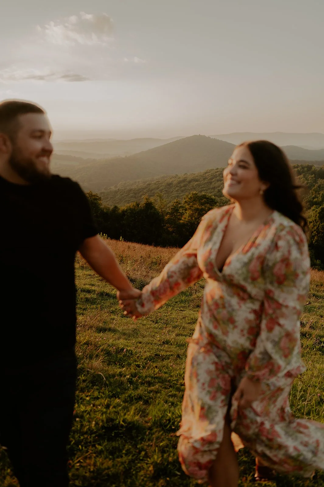 Couple holding hands and walking with mountains in the background