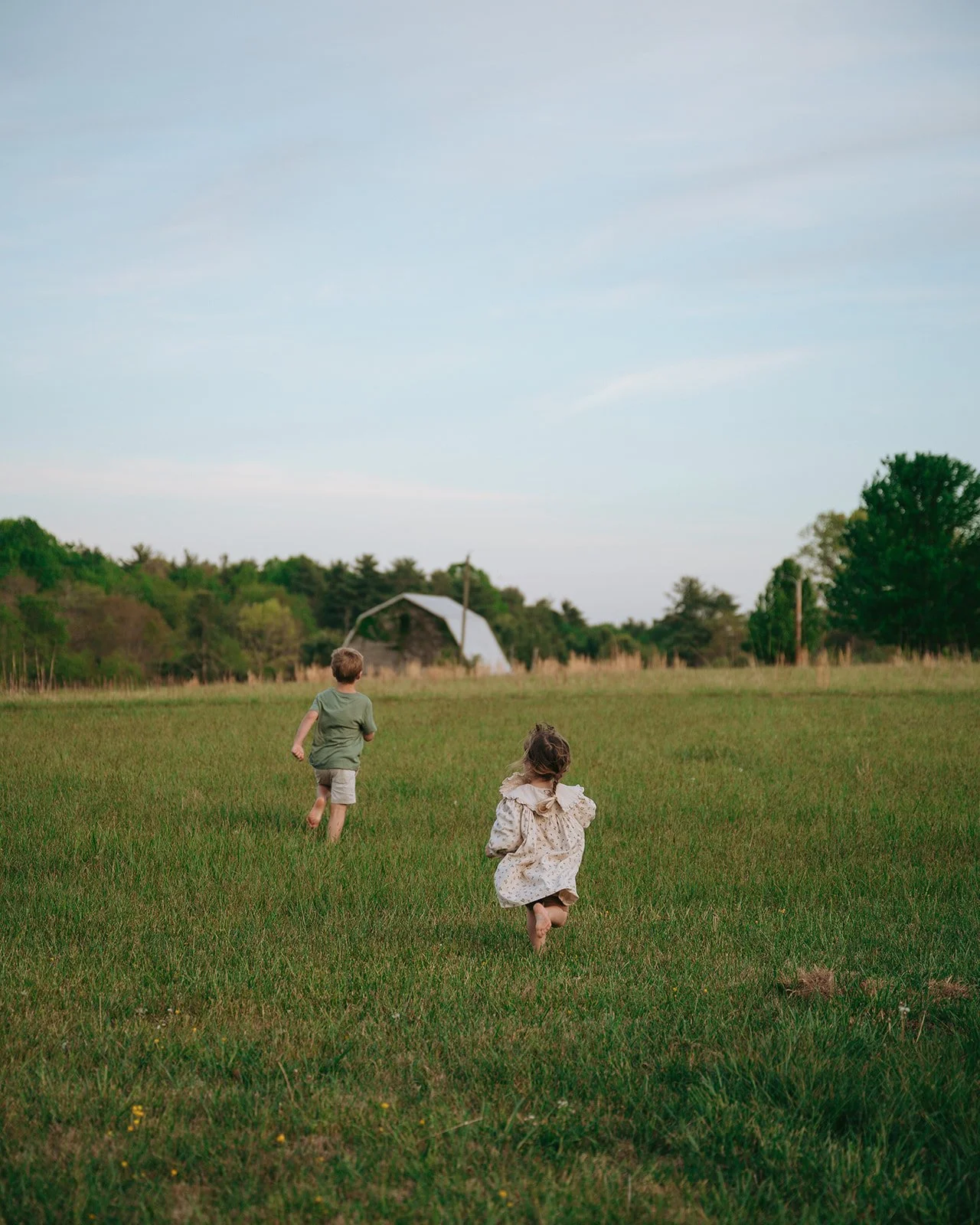 brother and sister running in field