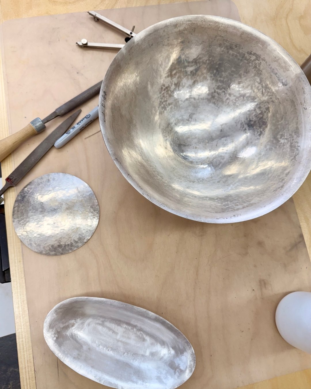 Raised silver bowls begin as a simple disc of metal. Through repeated hammering, annealing, and patient shaping, the silver slowly curves inward &mdash; compressing, thickening, and strengthening with every pass.
Raising is rhythmic, physical, and me