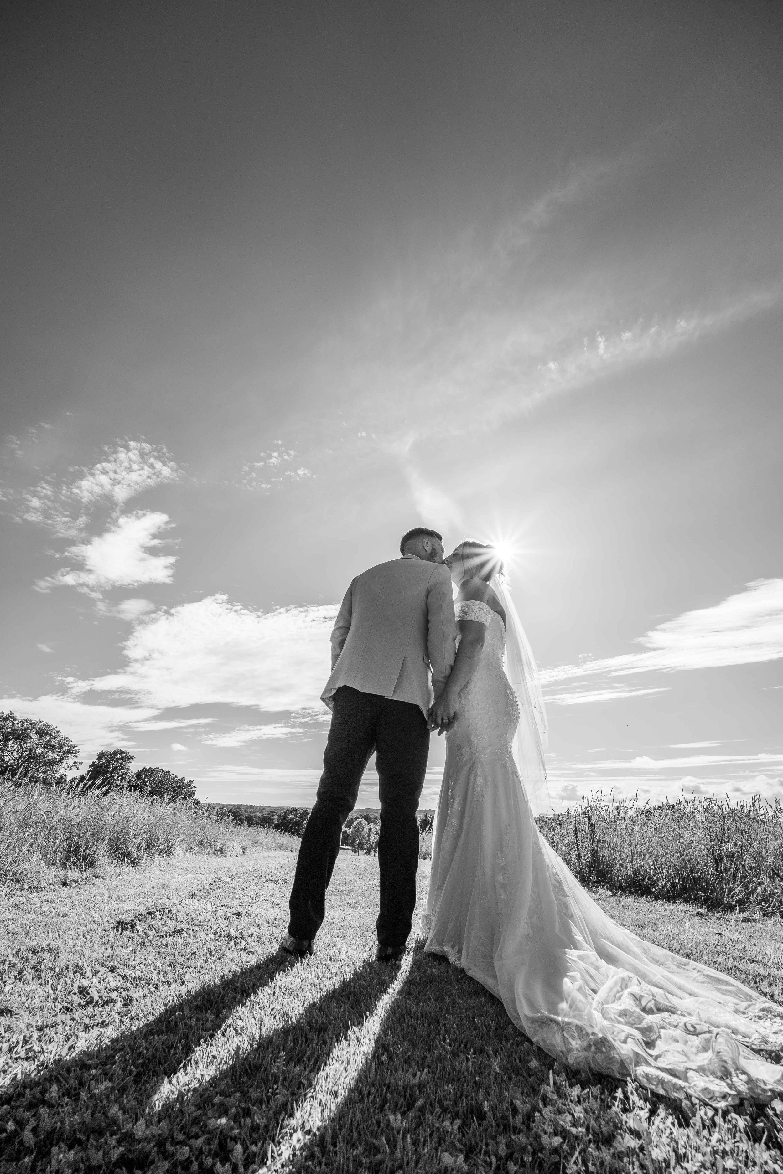 dramatic backlit portrait of newlyweds kissing .jpg