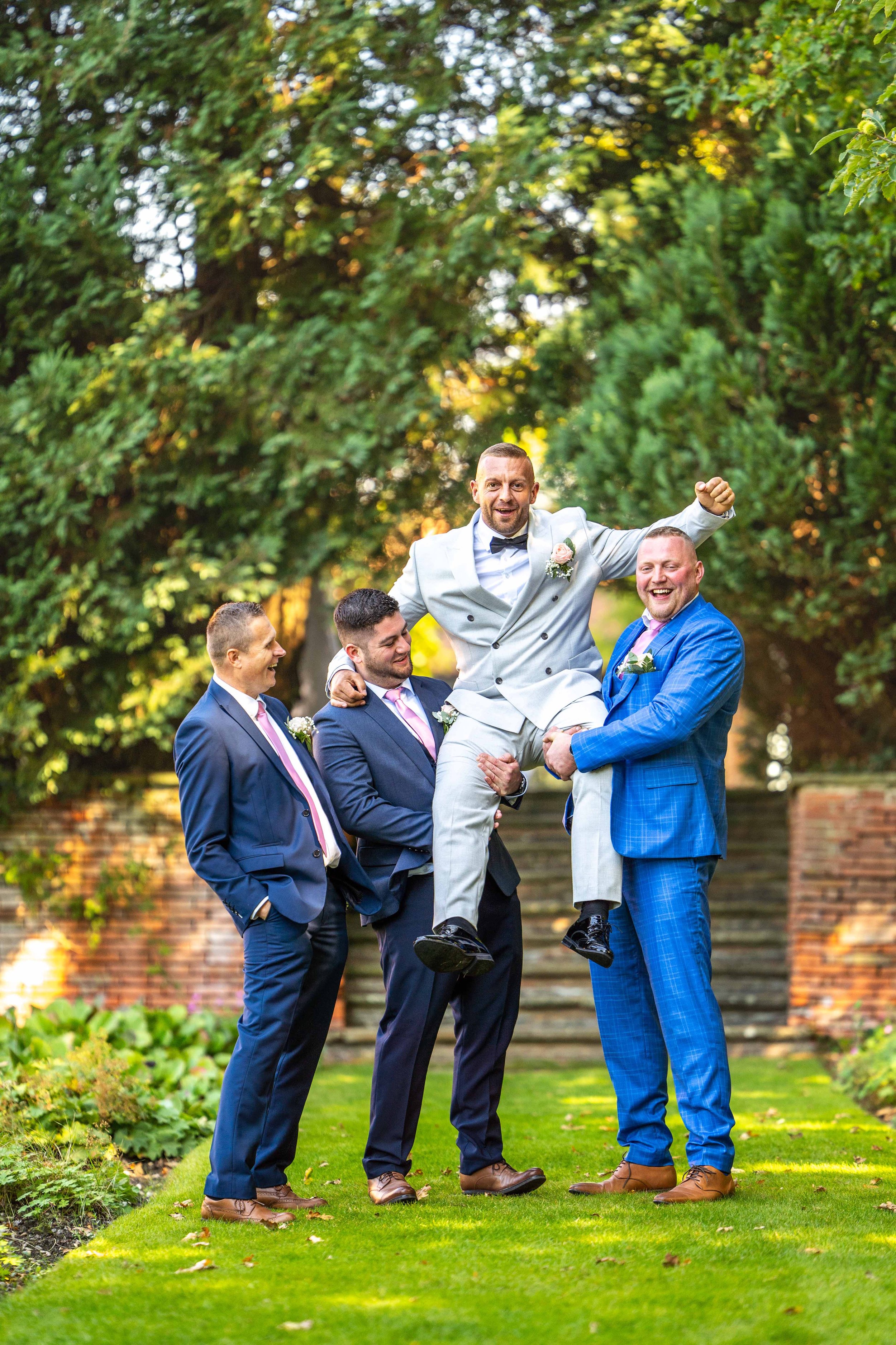 Groomsmen lifting up the groom in celebrations
