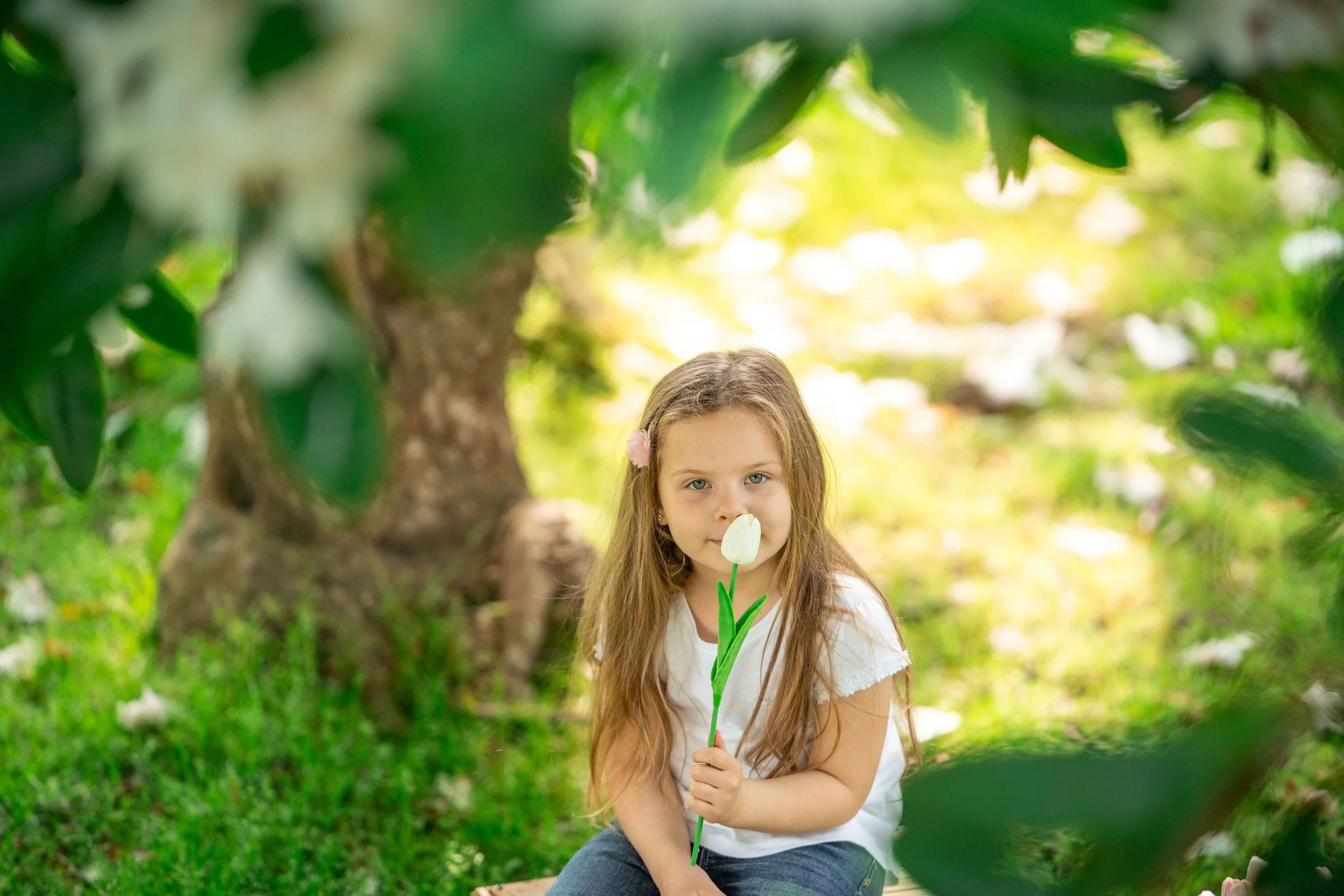 child holding a flower in a park
