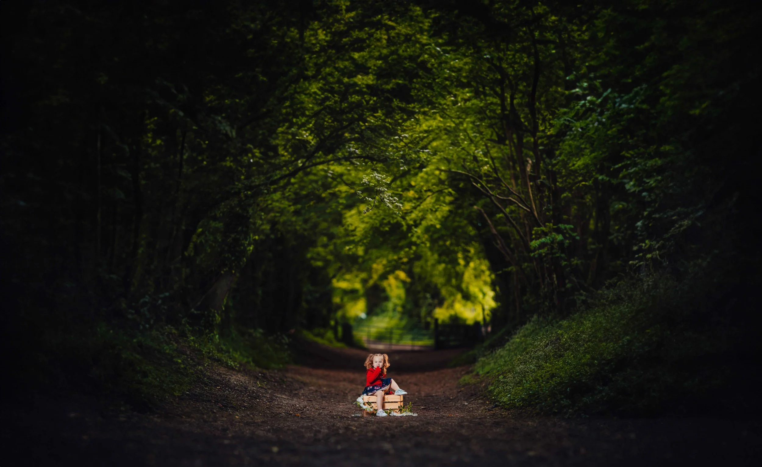 little girl in a tunnel made out of trees