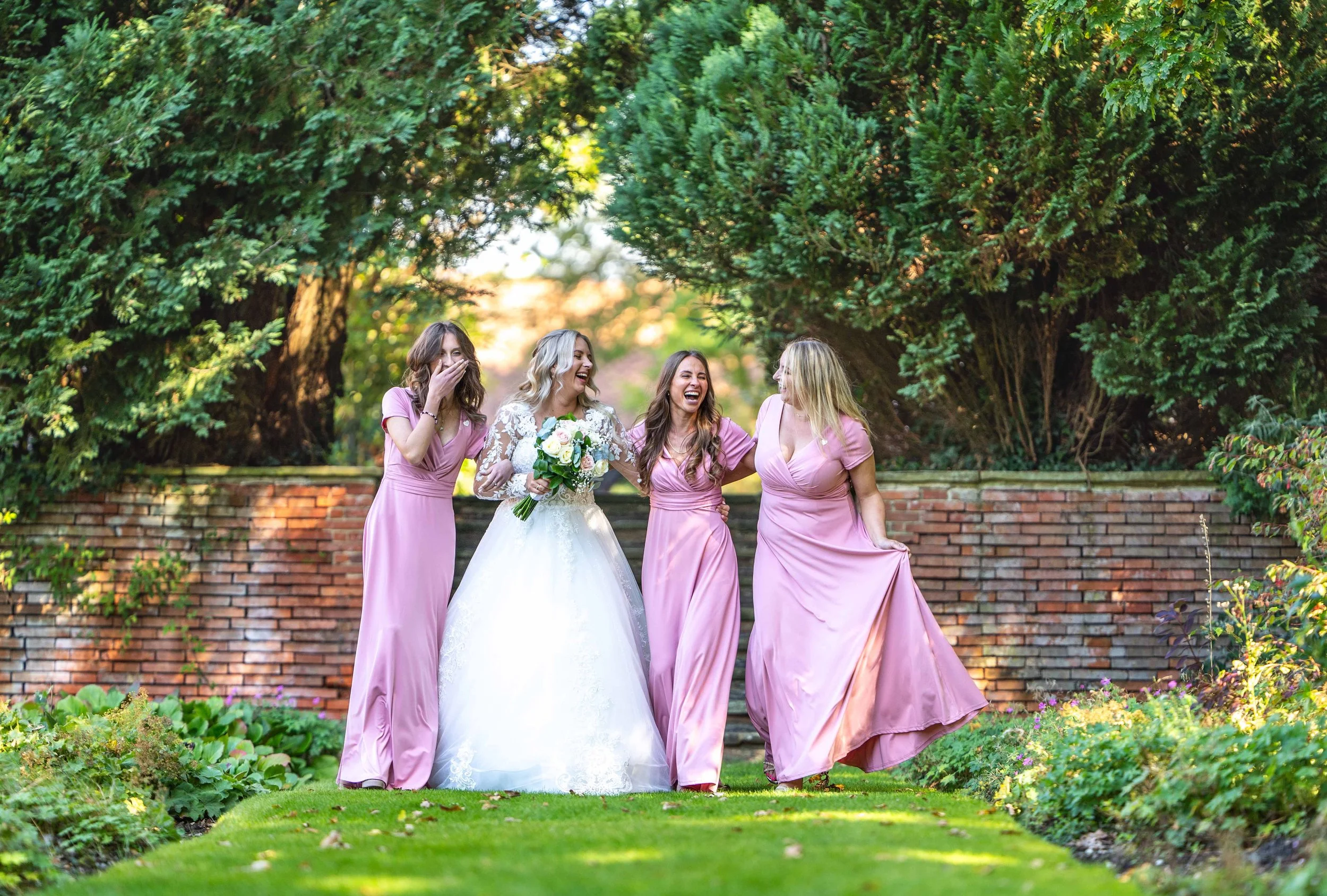 Bridesmaids walking with the bride at New place hotel in Hampshire