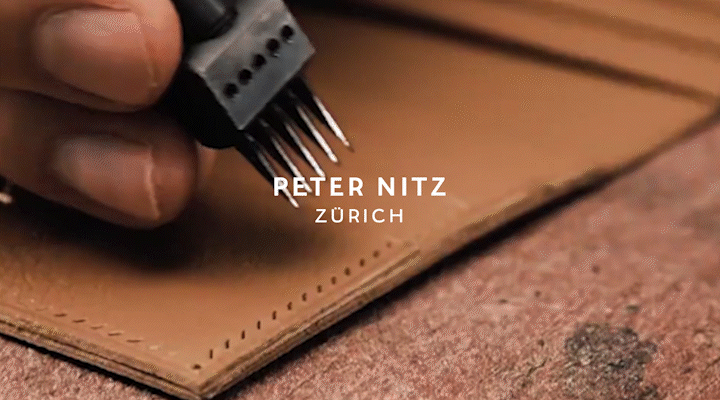 Close-up of a hand stitching leather with a sewing machine, with text overlay reading 'Reter Nitz Zürich'.