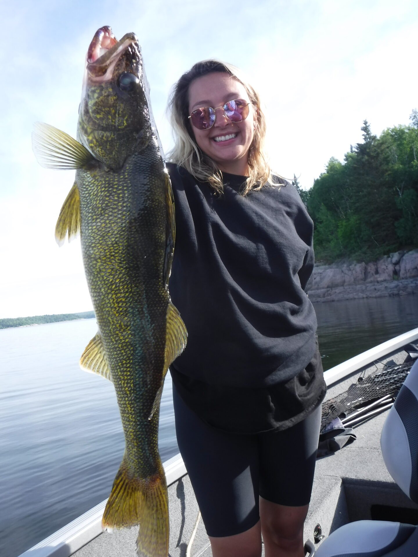 Person holding a large fish on a boat