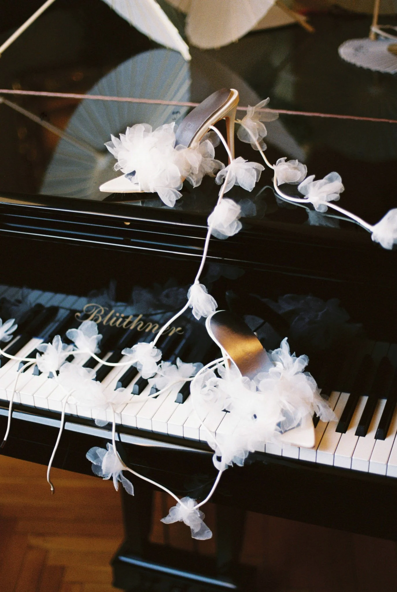 Editorial detail photo of bridal shoes on a piano.