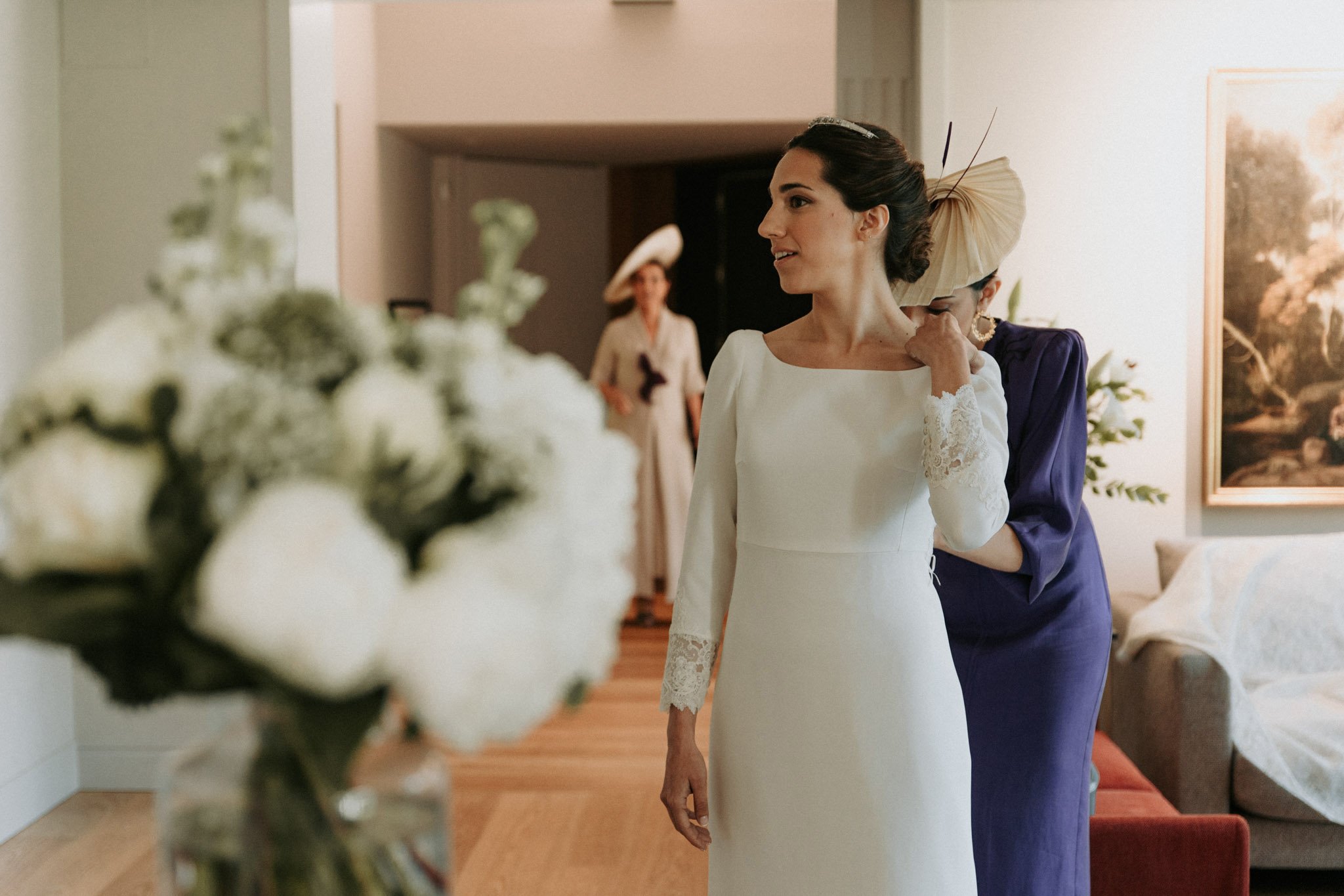 bride-getting-dressed-at-home-with-her-sister-Xalet-de-nin-barcelona-destination-wedding-photographer.jpg