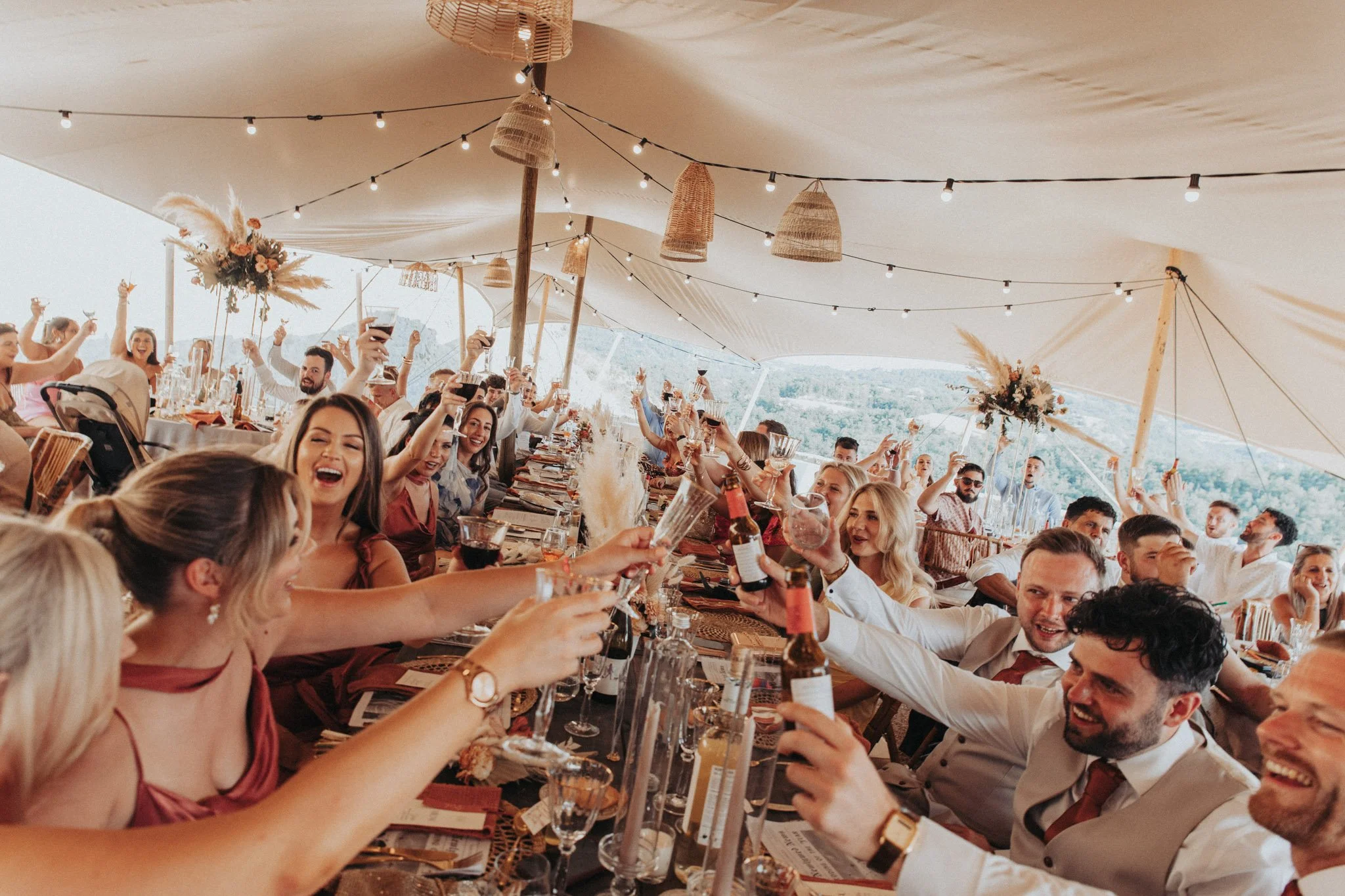 wedding-guests-toast-at-dinner-candid-shot-castell-d-enfesta-barcelona-destination-wedding-photographer.jpg