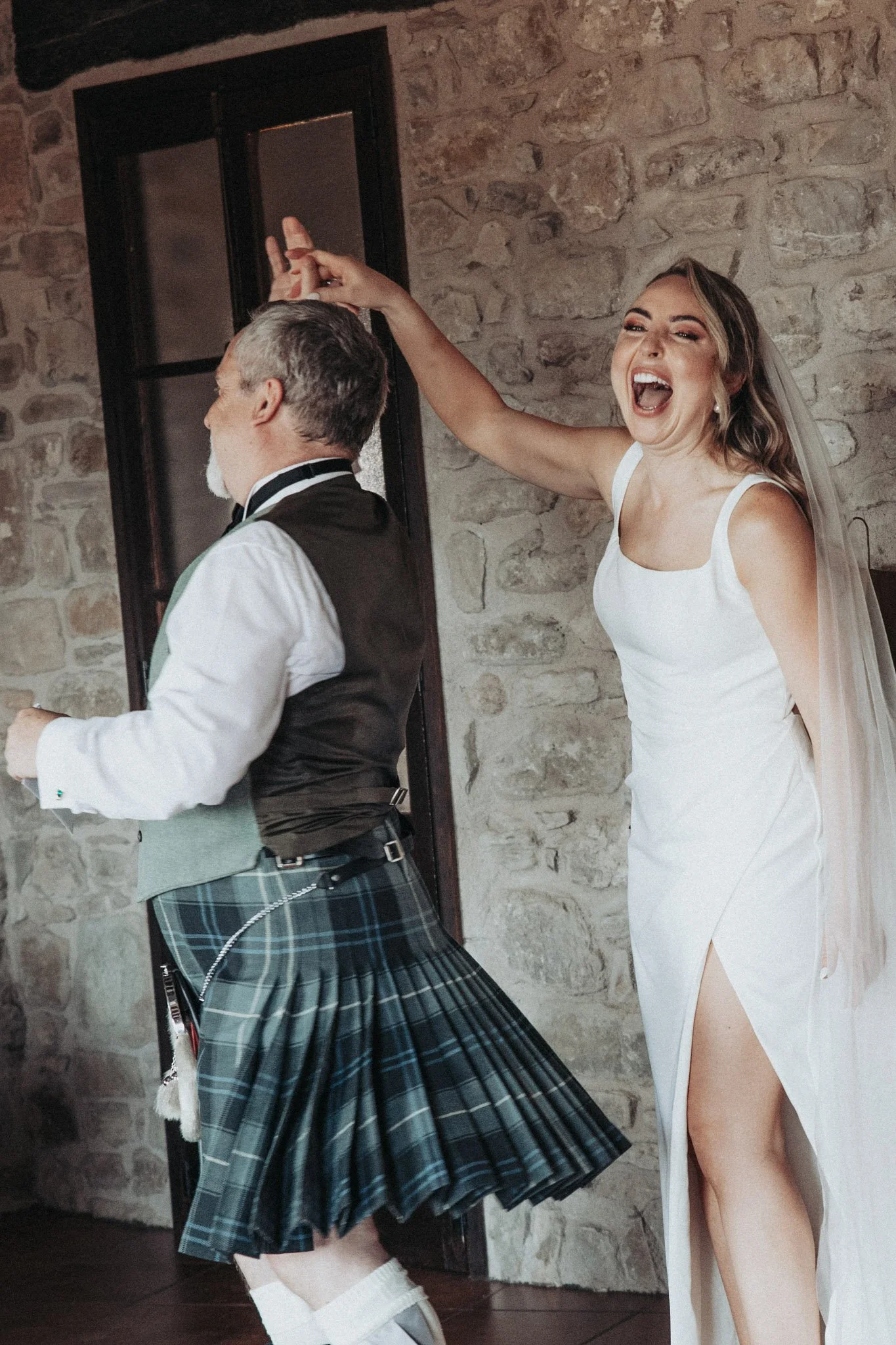 fun-candid-portrait-of-bride-with-dad-in-traditional-scottish-outfit-kilt-mas-terrats-girona-destination-wedding-photographer.jpg