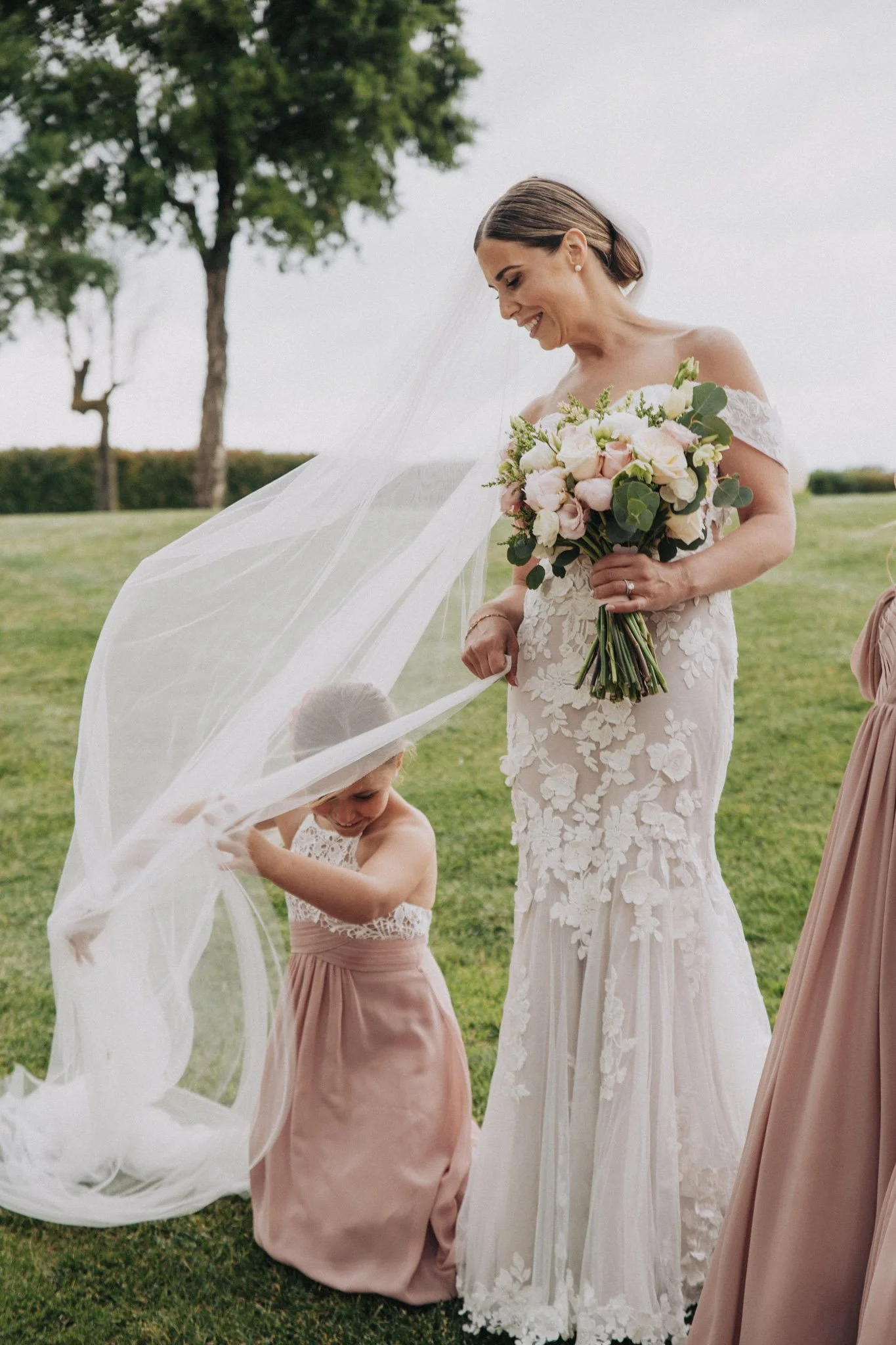 Retrato divertido de novia con dama de honor en jardines Mas de Alzedo