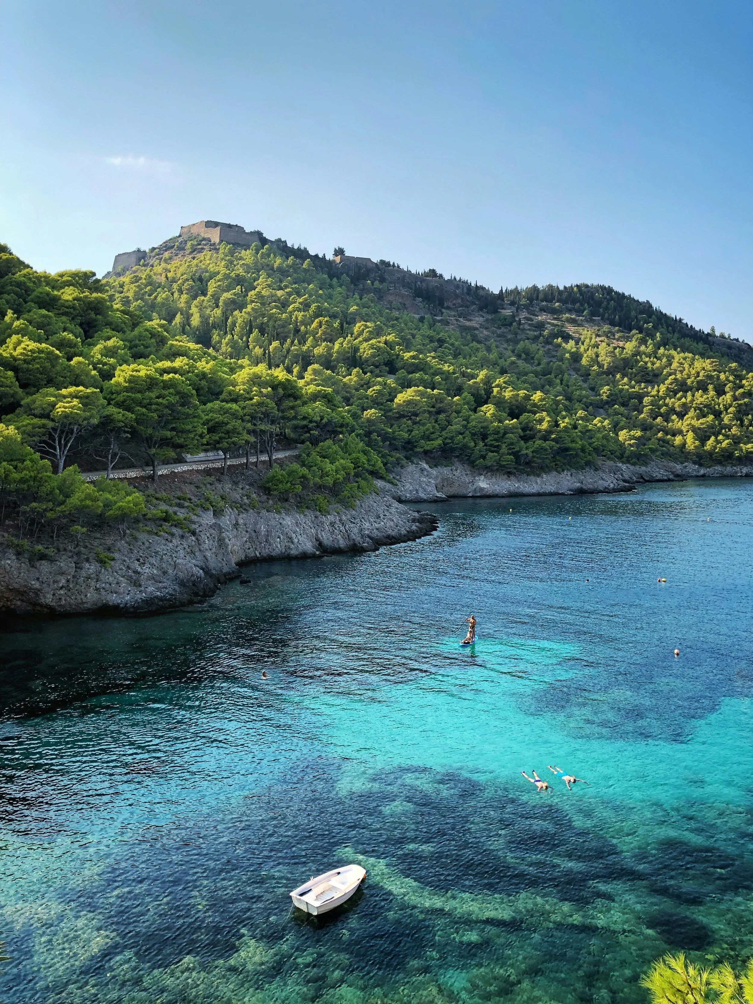 A photo of the sea with beautiful greenery surrounding it