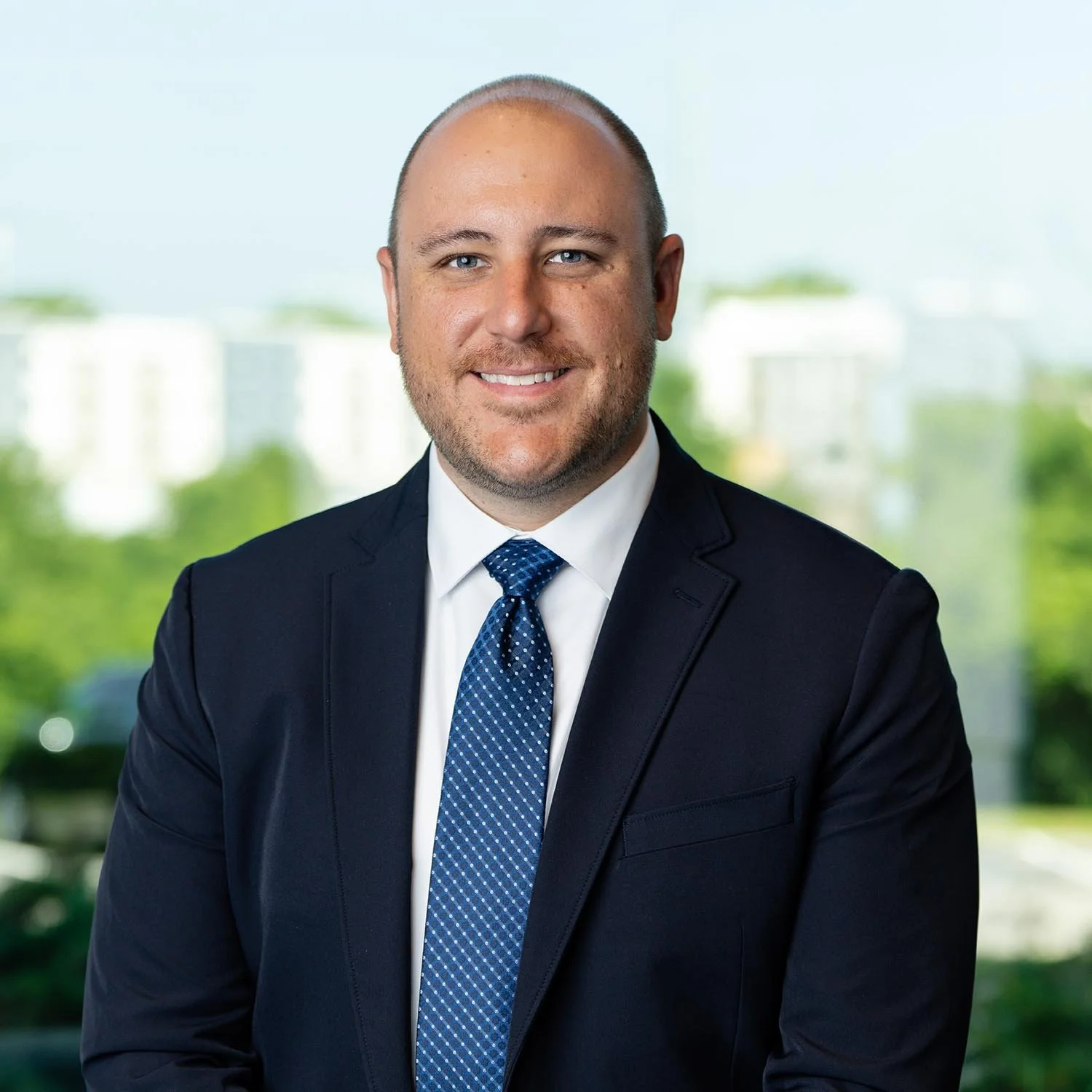 Eric Gumm in dark suit and blue tie