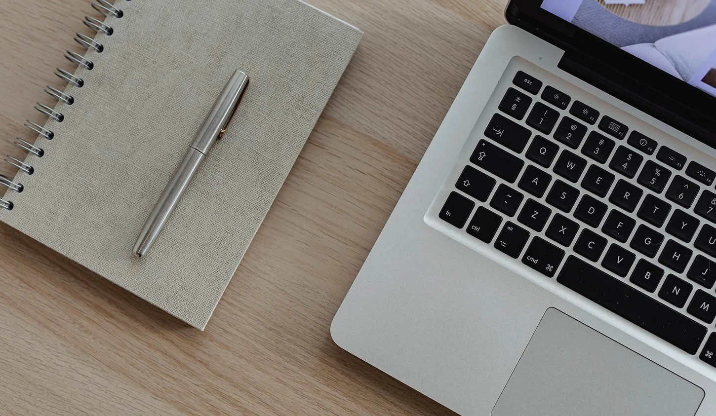 laptop with notebook and pen