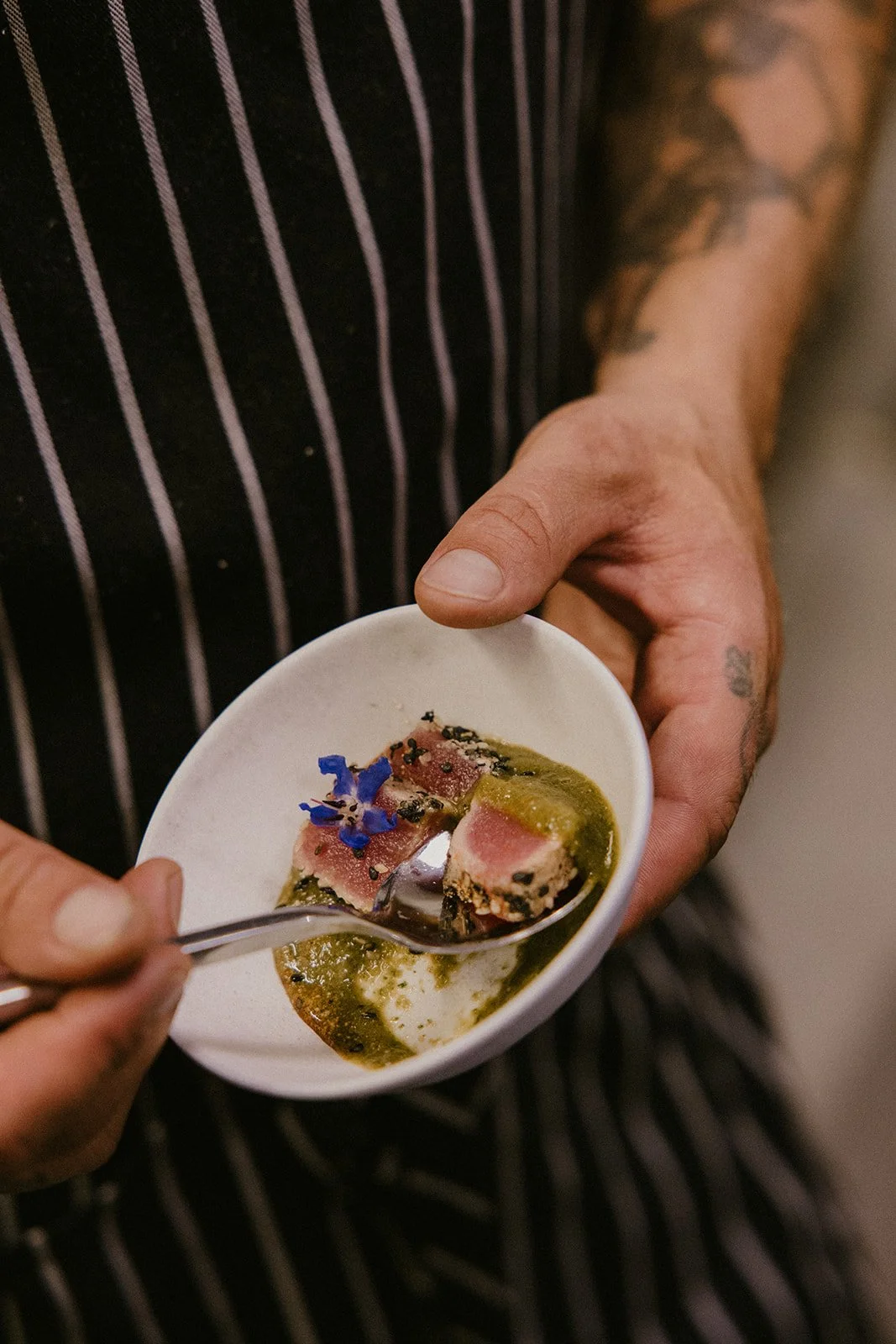 Chef serving a finished Gold Epicure appetizer at a catered event