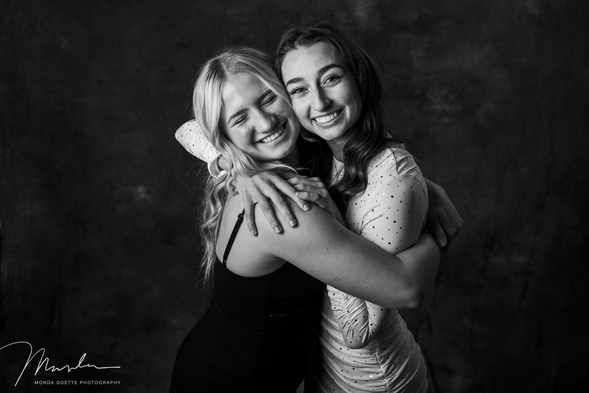 Two high school senior girls hugging during photo session at Monda Goette Photography in the Twin Cities.