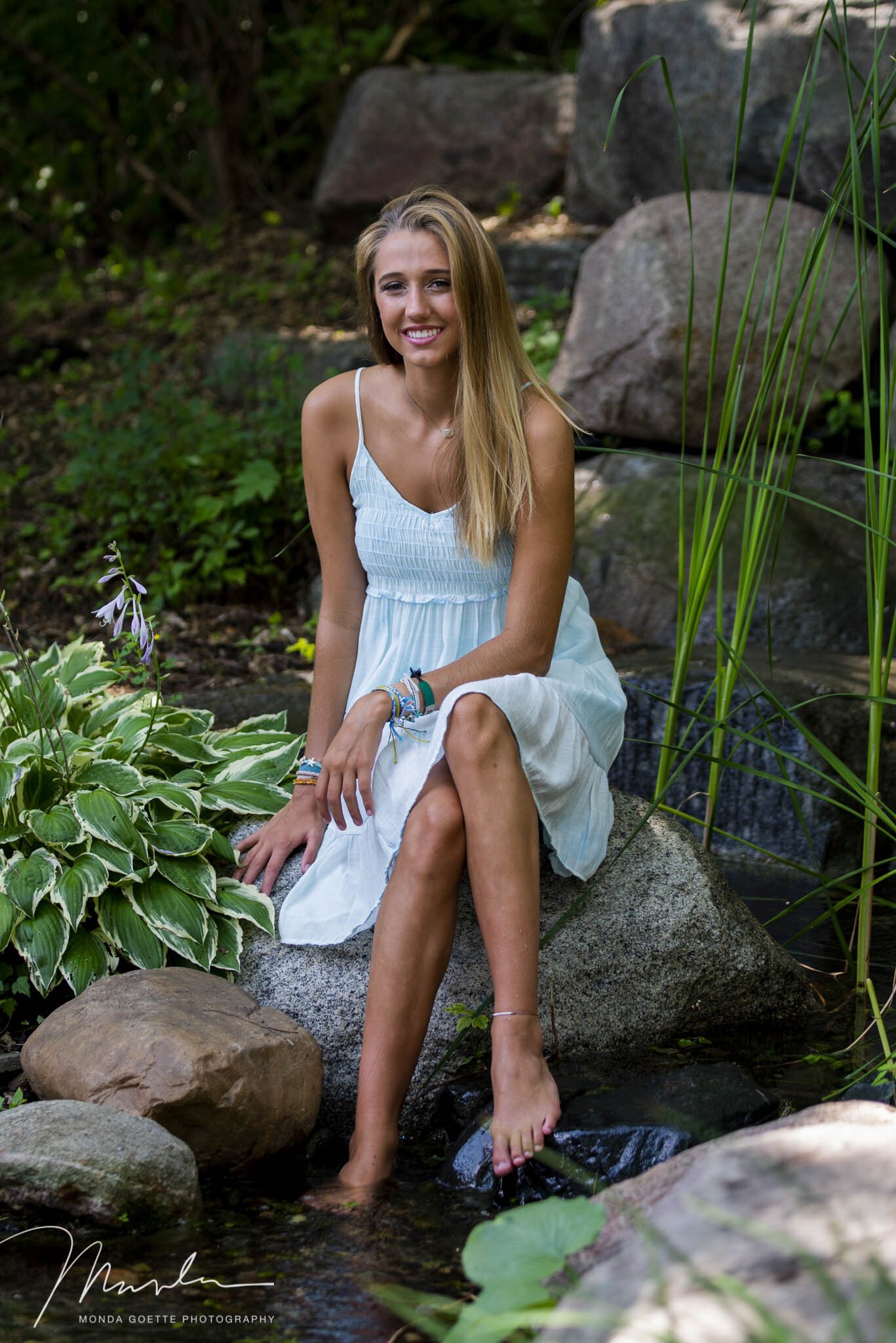 Senior photo session at Monda Goette Photography of a girl smiling near the rocks.