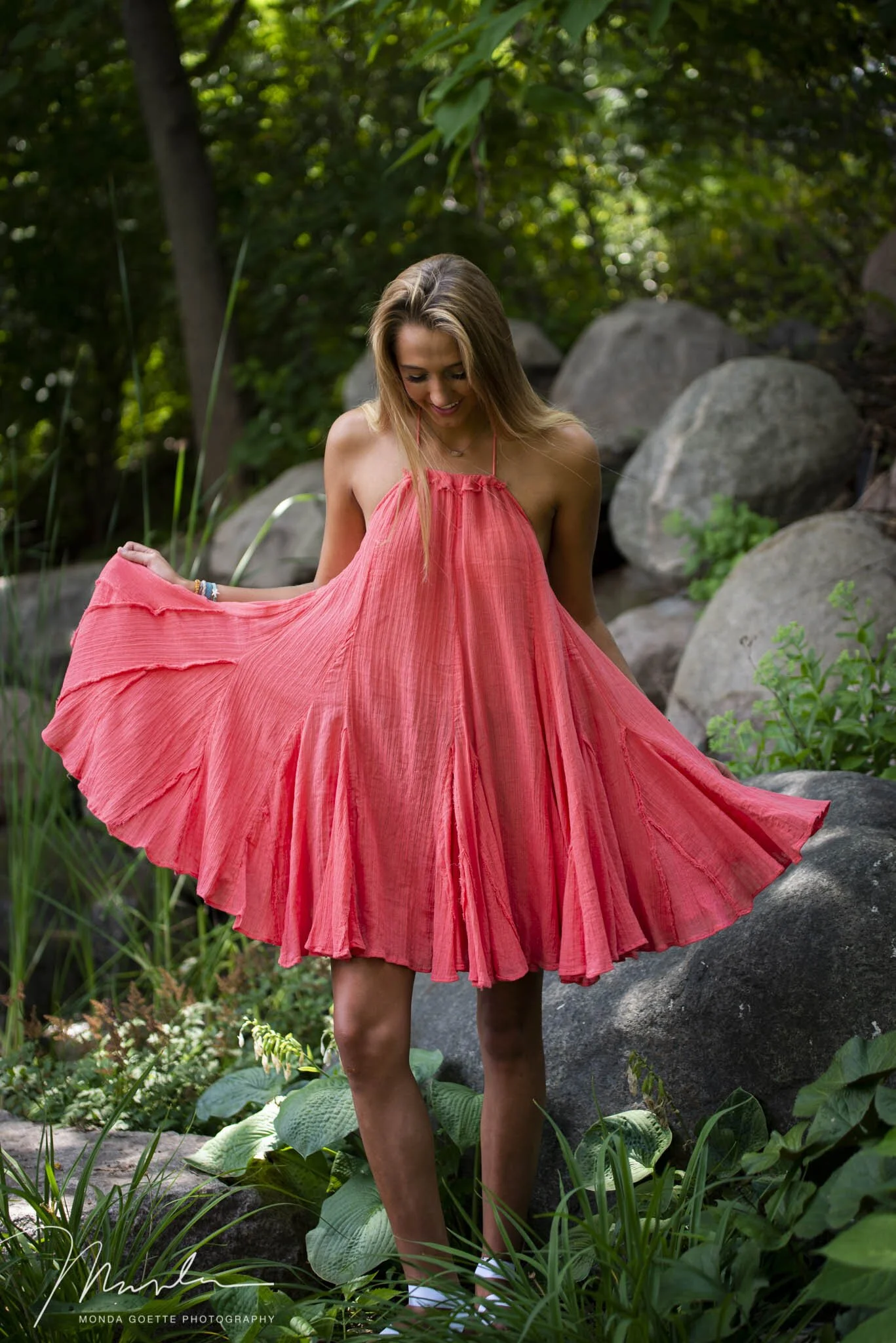 Beautiful high school senior girl twirling her dress in back garden studio lot in the Twin Cities.