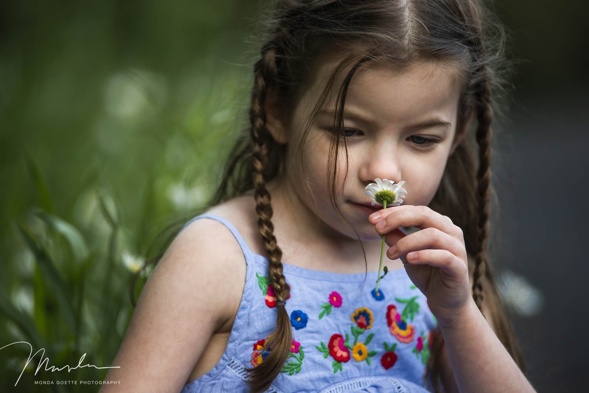 a young girl smelling the flowers