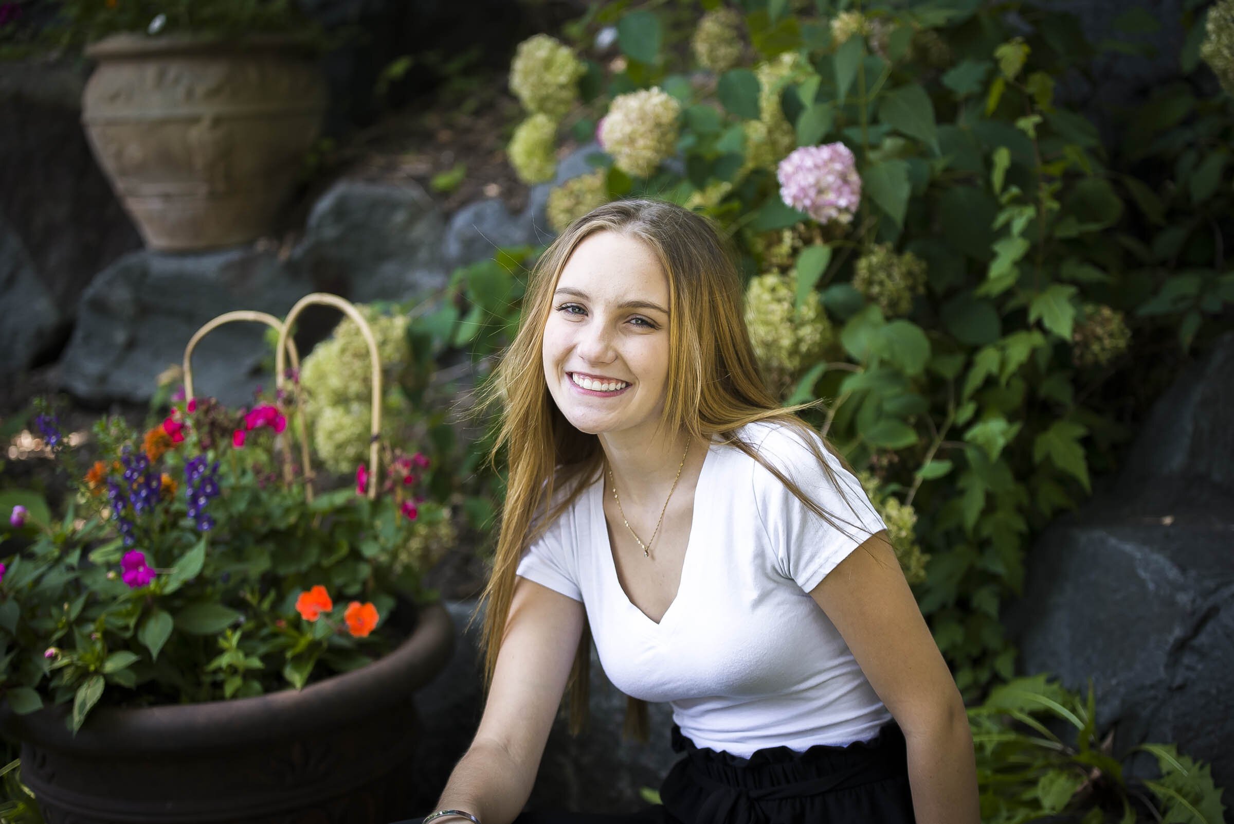 Senior Girl smiling in Minnesota waterfall garden