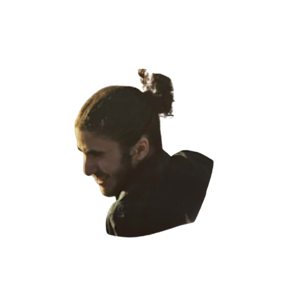 A man smiling, carrying a skateboard on his shoulder, captured in profile against a black background.