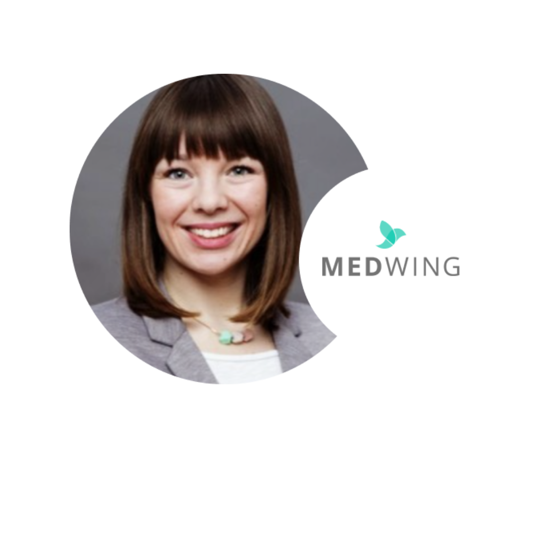 A professional woman with shoulder-length brown hair, smiling, wearing a gray blazer and a necklace with a teal pendant. There is a logo for MEDWING, featuring a teal leaf, next to her.