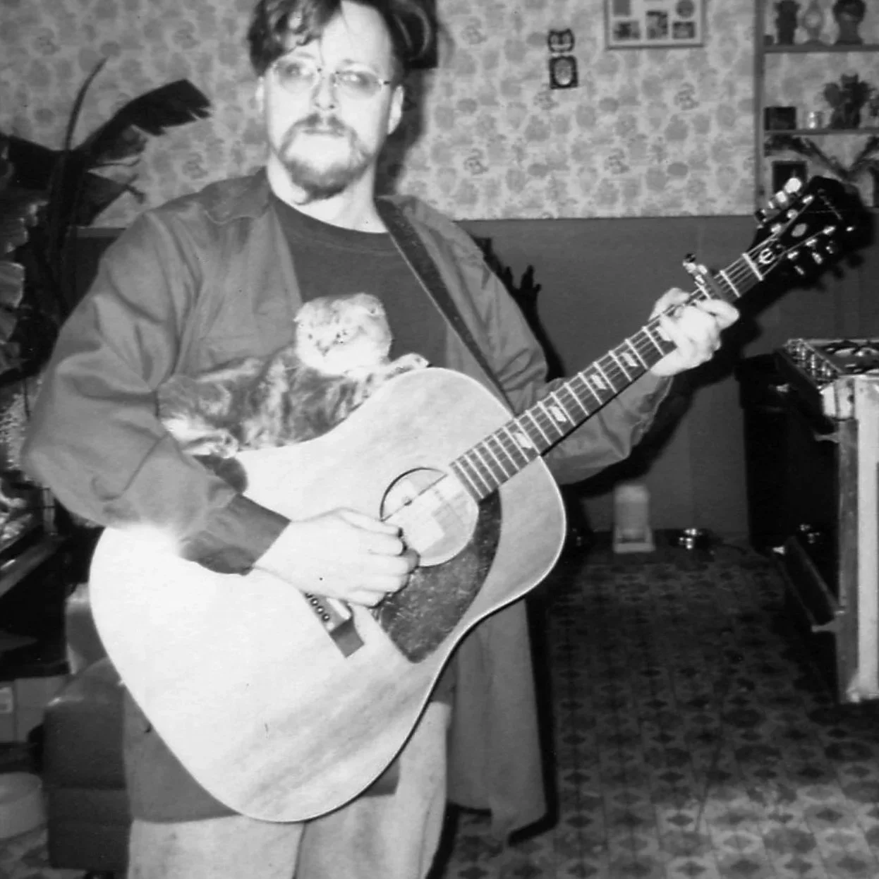 Luthier Michael Swanson in the 1990s with his '67 Epiphone Texan, his Scottish Fold cat Icky lying on top of the guitar.